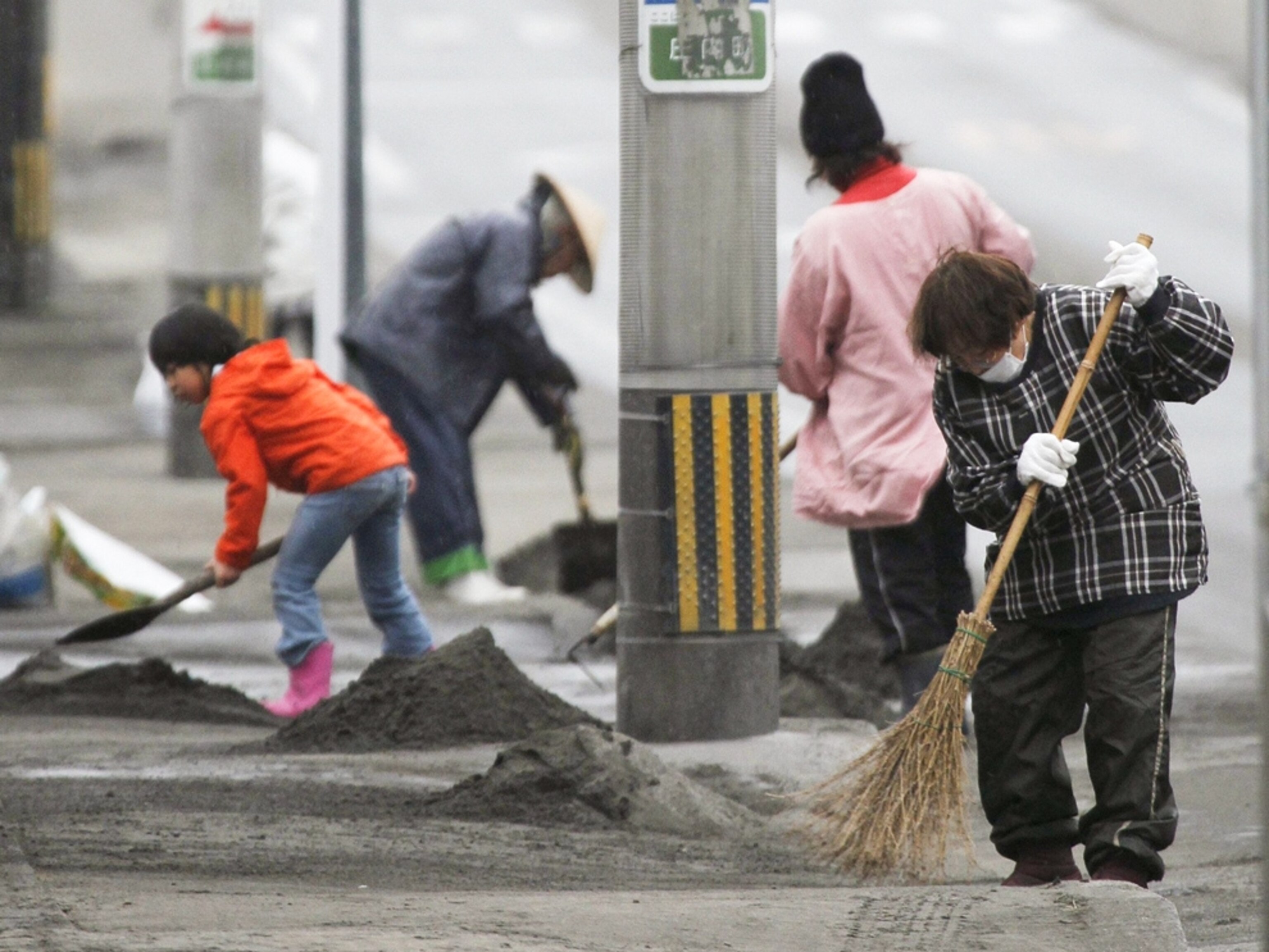 People sweeping ash from Japanese volcano picture