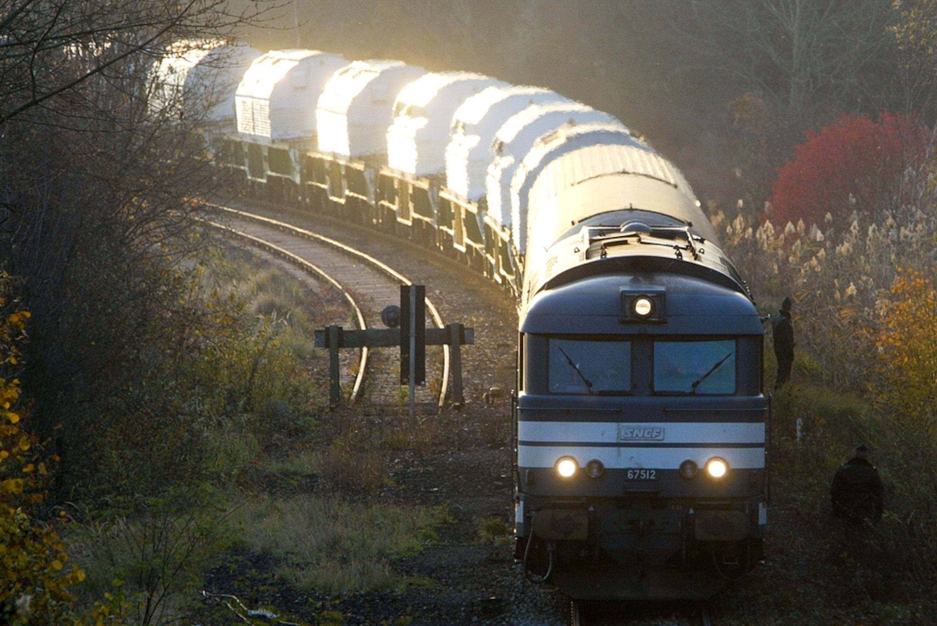 A train, carrying canisters of nuclear waste, rounds a bend and heads towards the camera (picture)