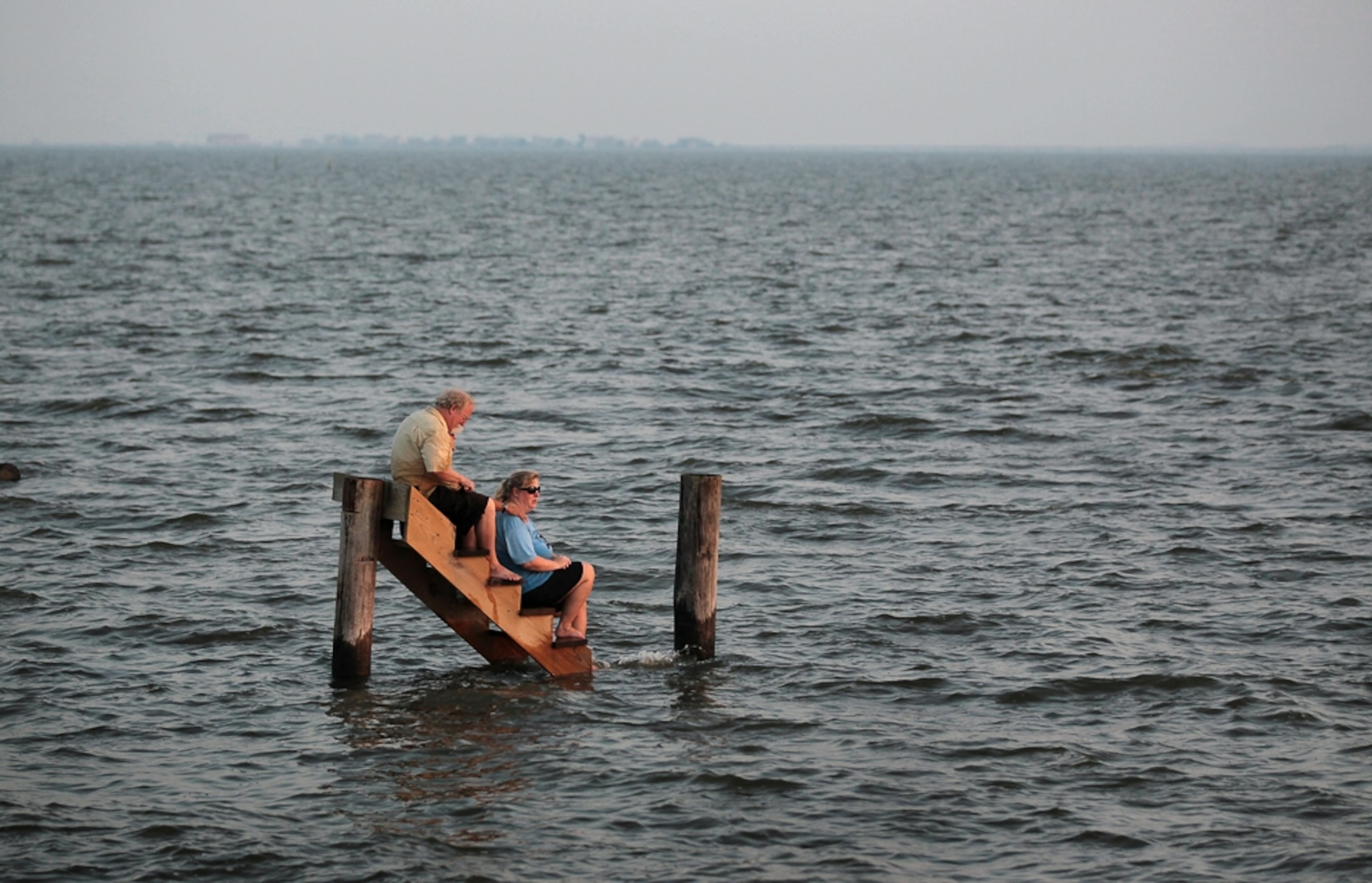 Hurricane Irene picture: people surrounded by water on the steps of a destroyed cottage -- for best pictures of August photo gallery