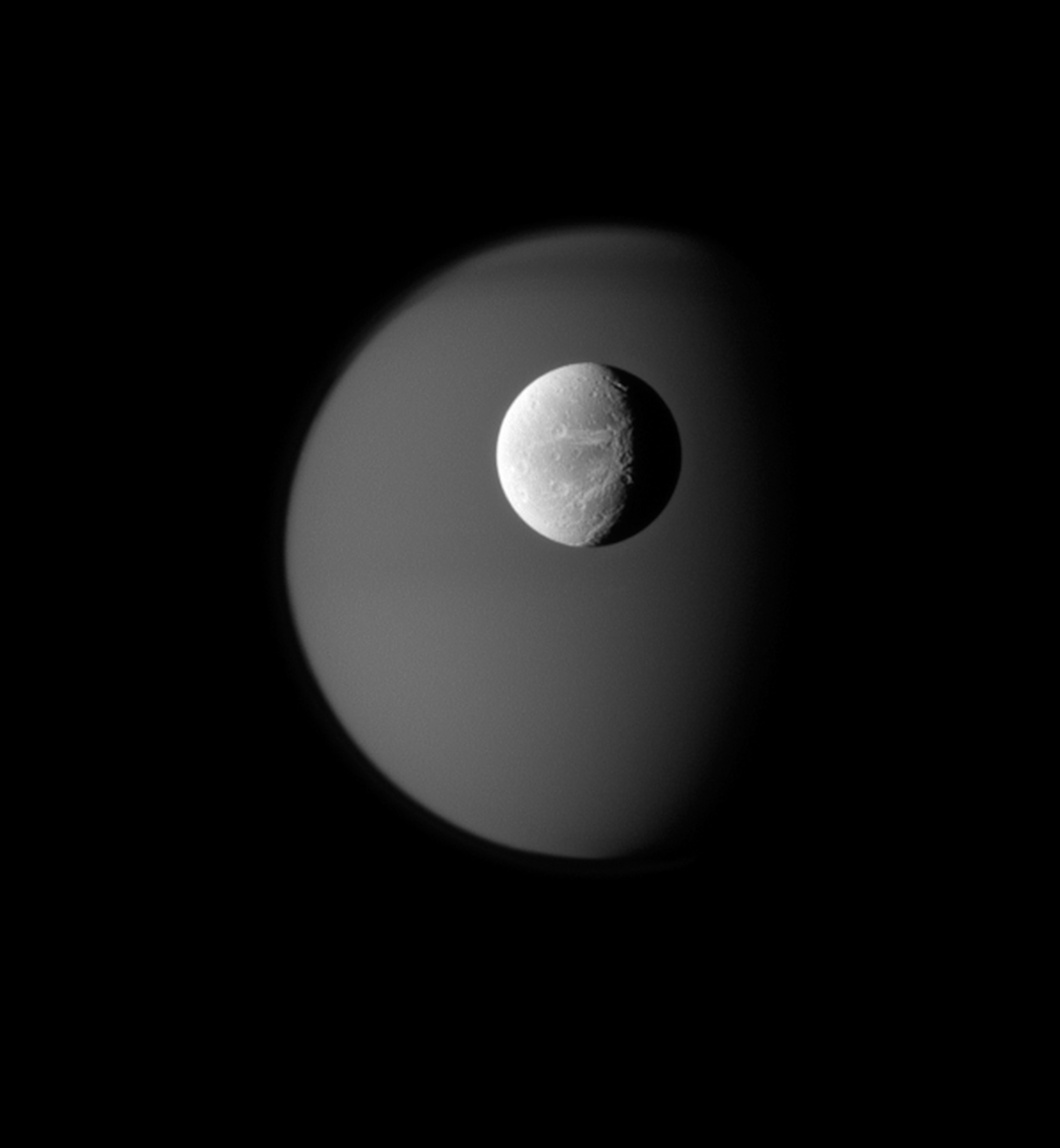 Saturn's moon Dione in front of the larger moon Titan.