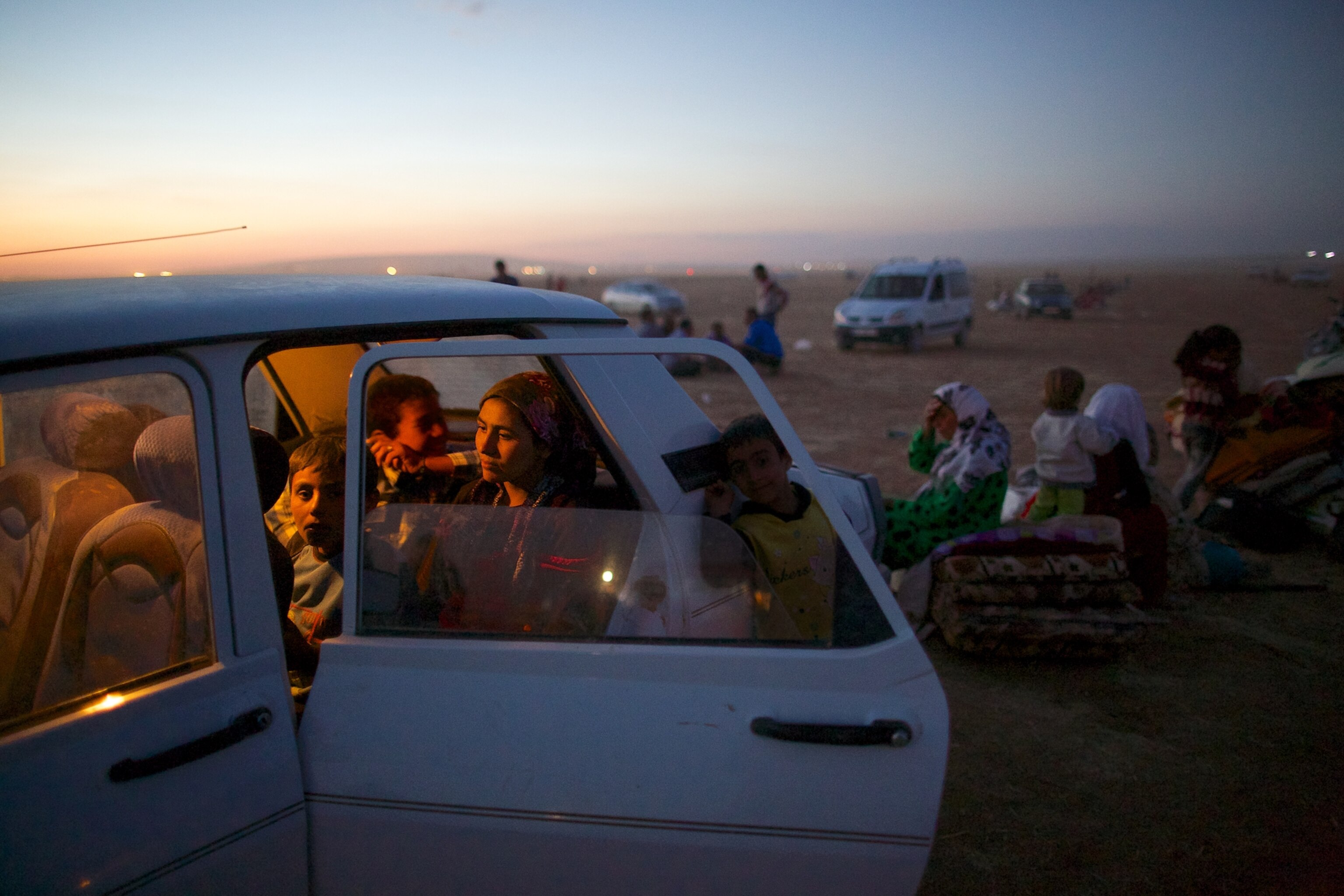 a Syrian women carrying a baby after fleeing to Turkey with thousands of others.