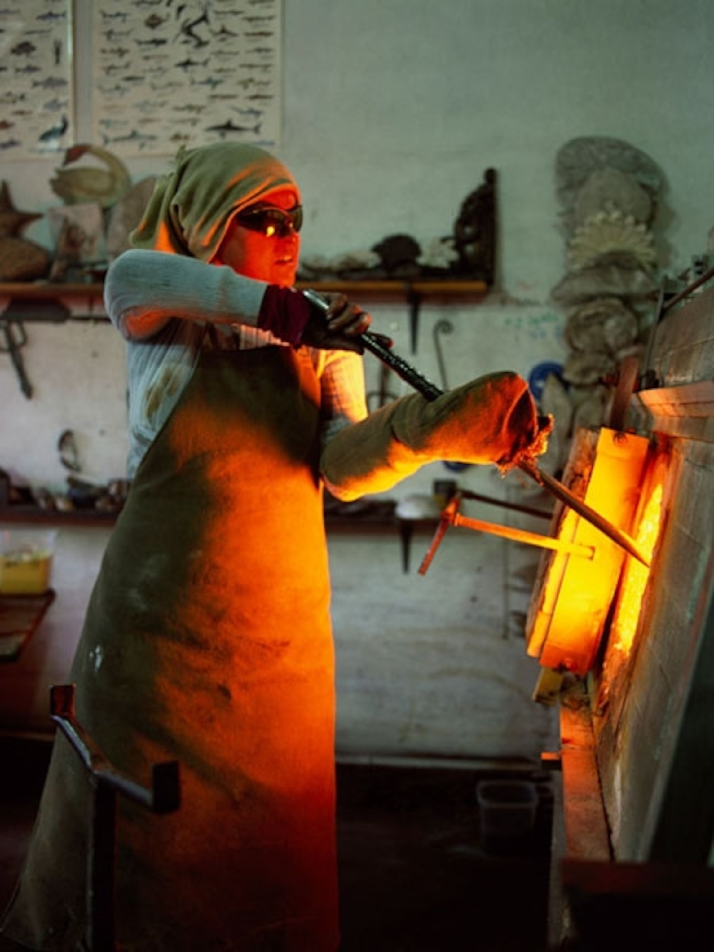 Glass maker holds a rod into a kiln