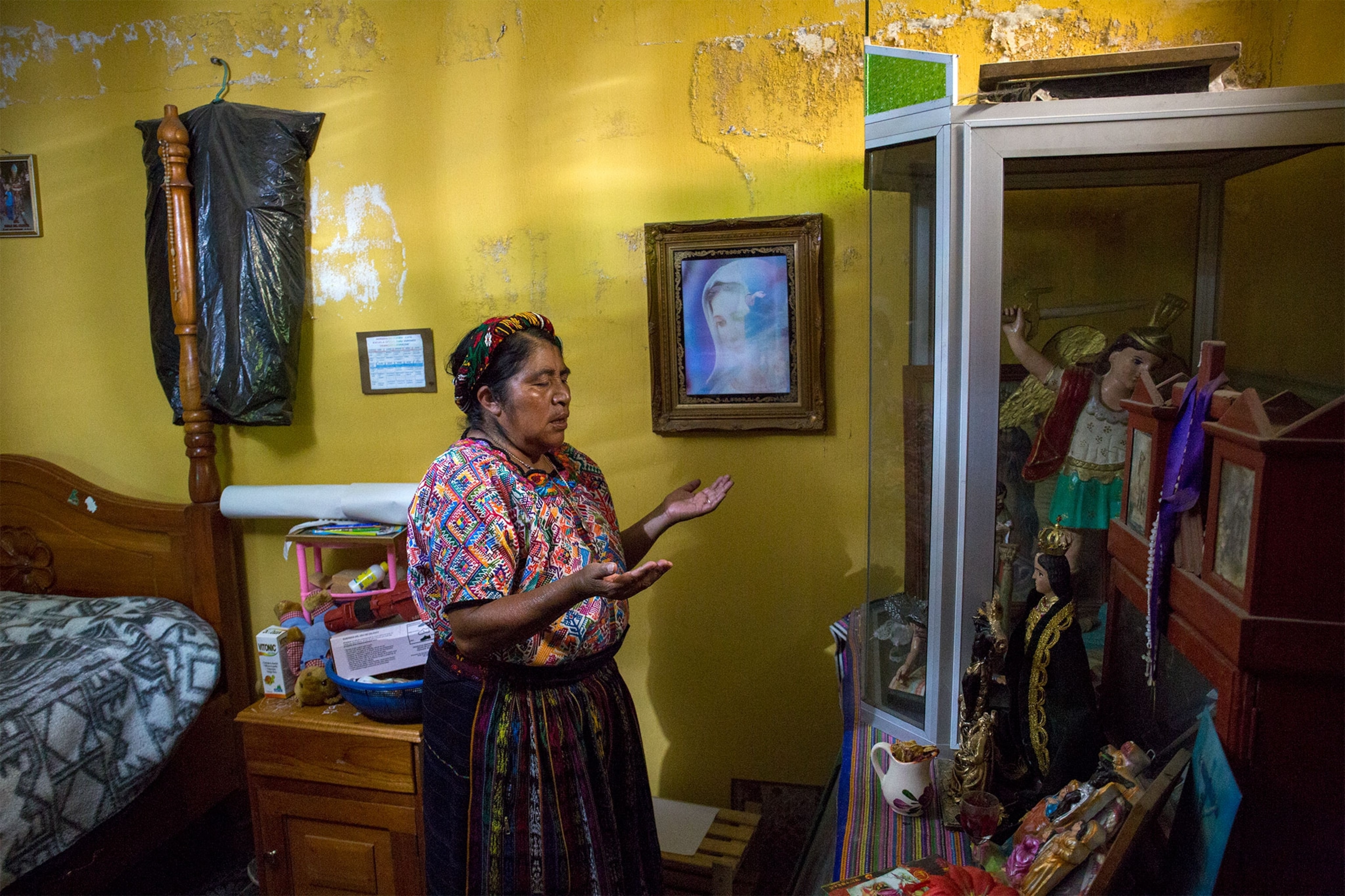 a woman praying in her home in Guatemala