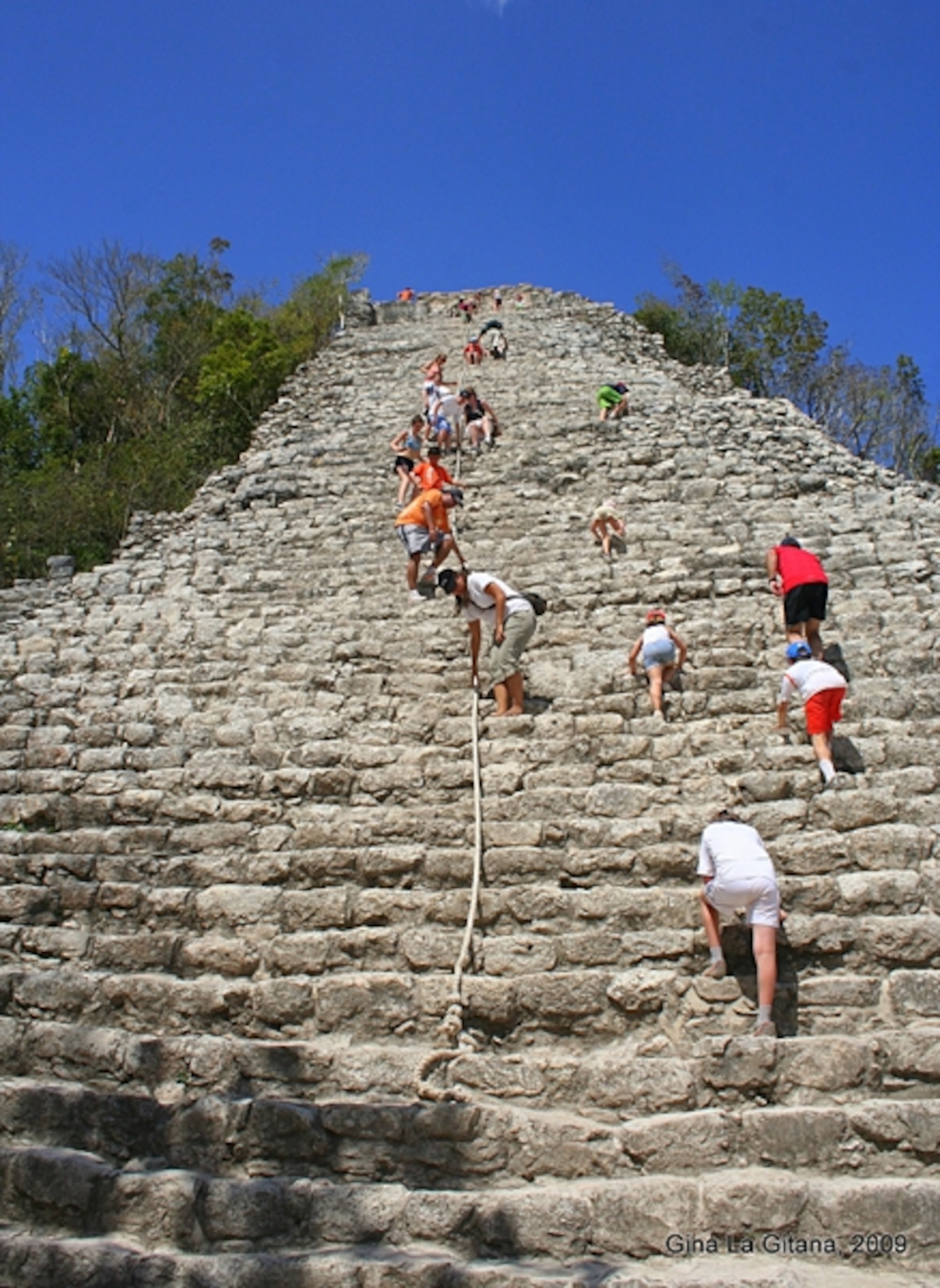 visitors climbing a Maya temple at Coba, Mexico