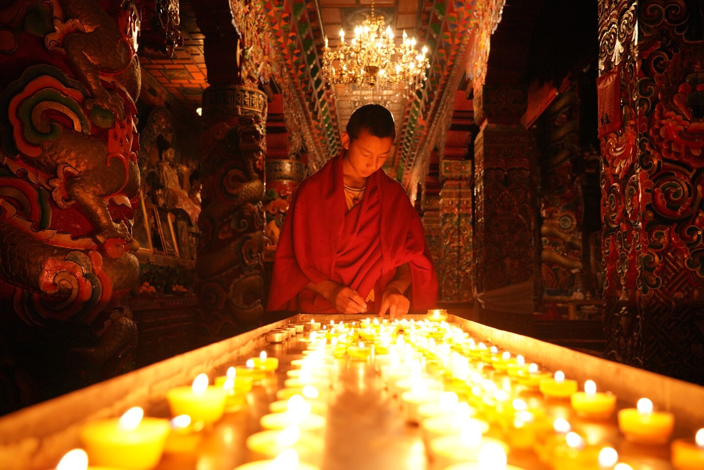 Photo of a monk lit by candles