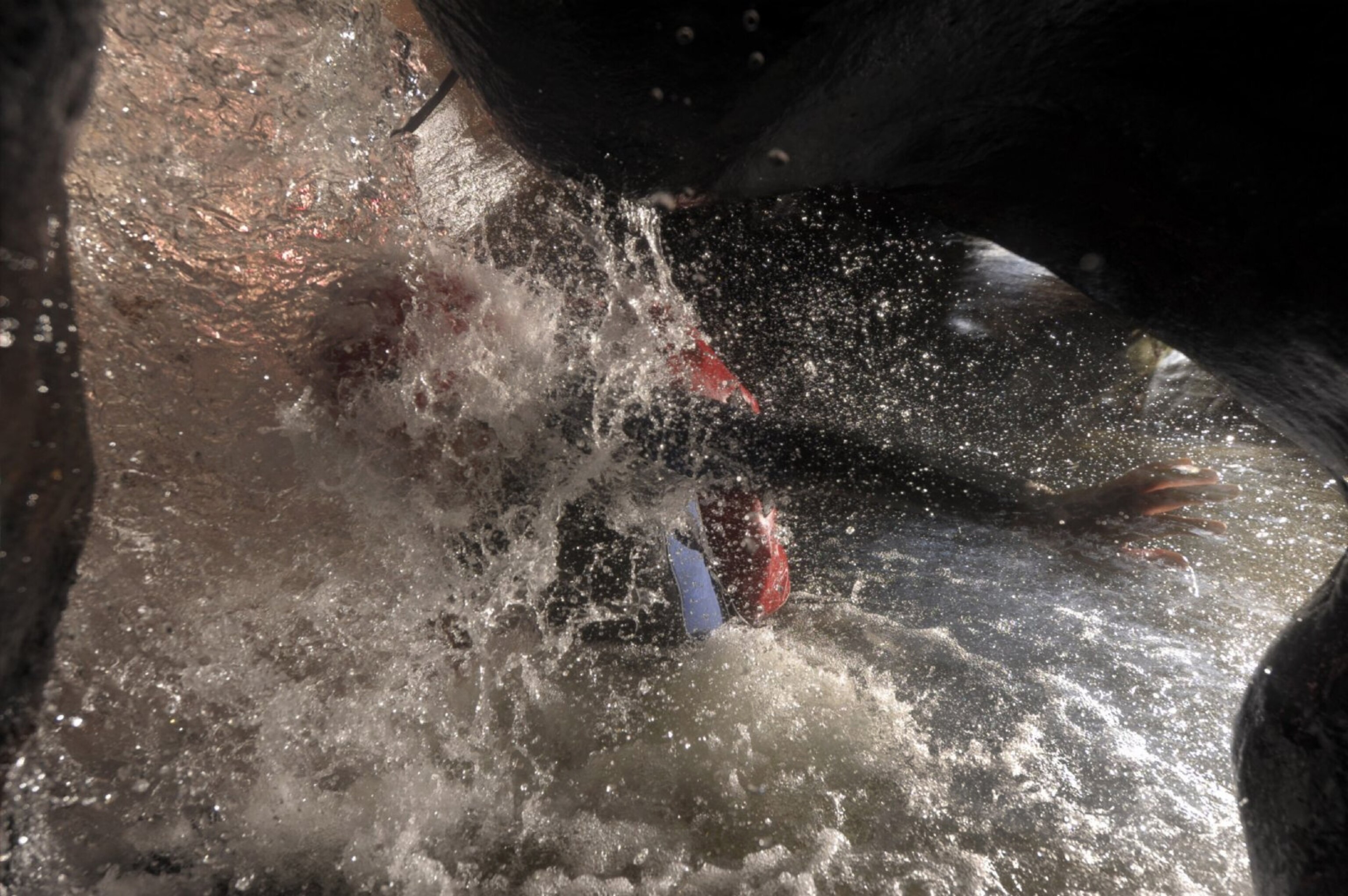 a canyoneer fighting to emerge from beneath one of Claustral Canyon’s many waterfalls