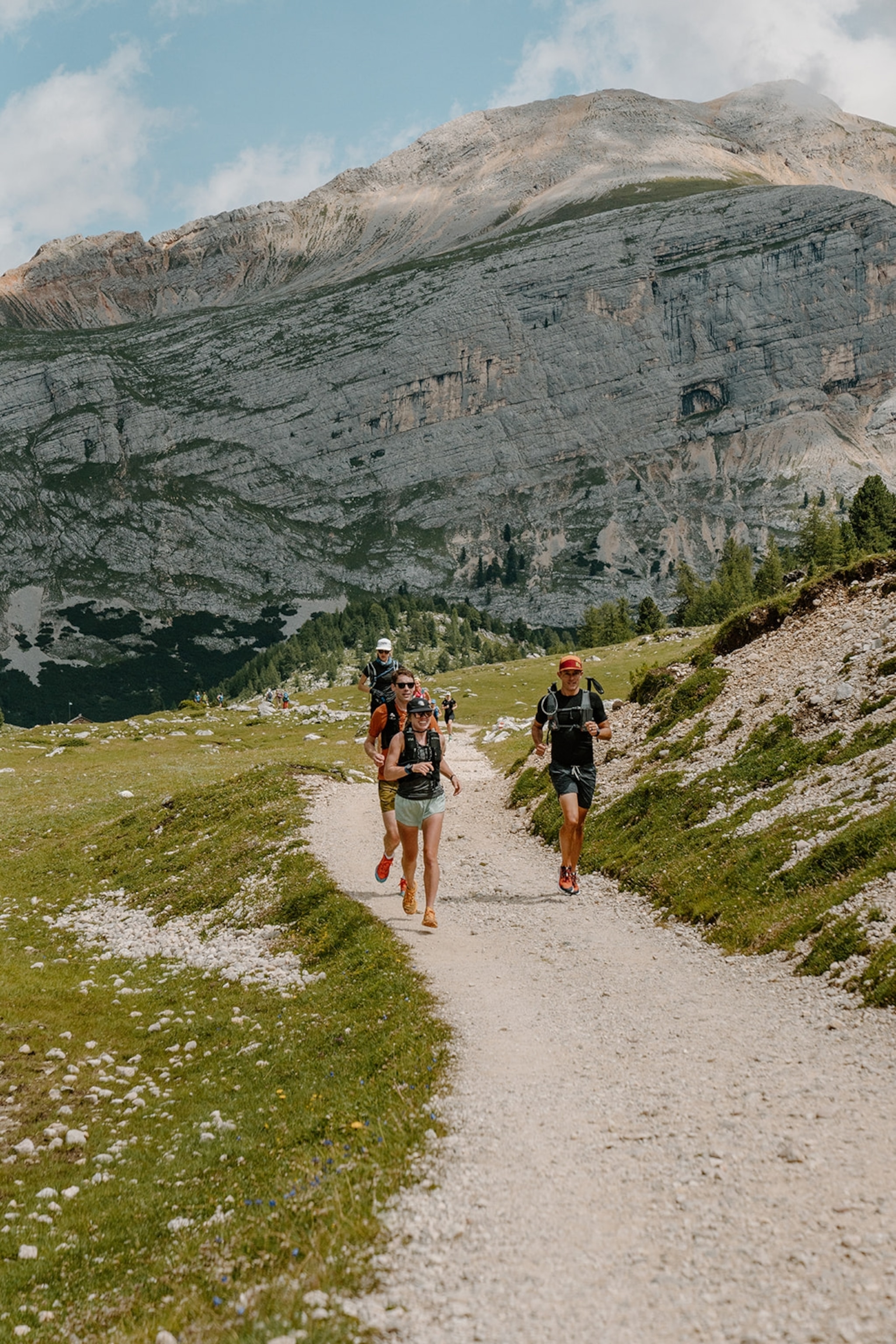 A group of runners with a large Dolomite mountains behind them