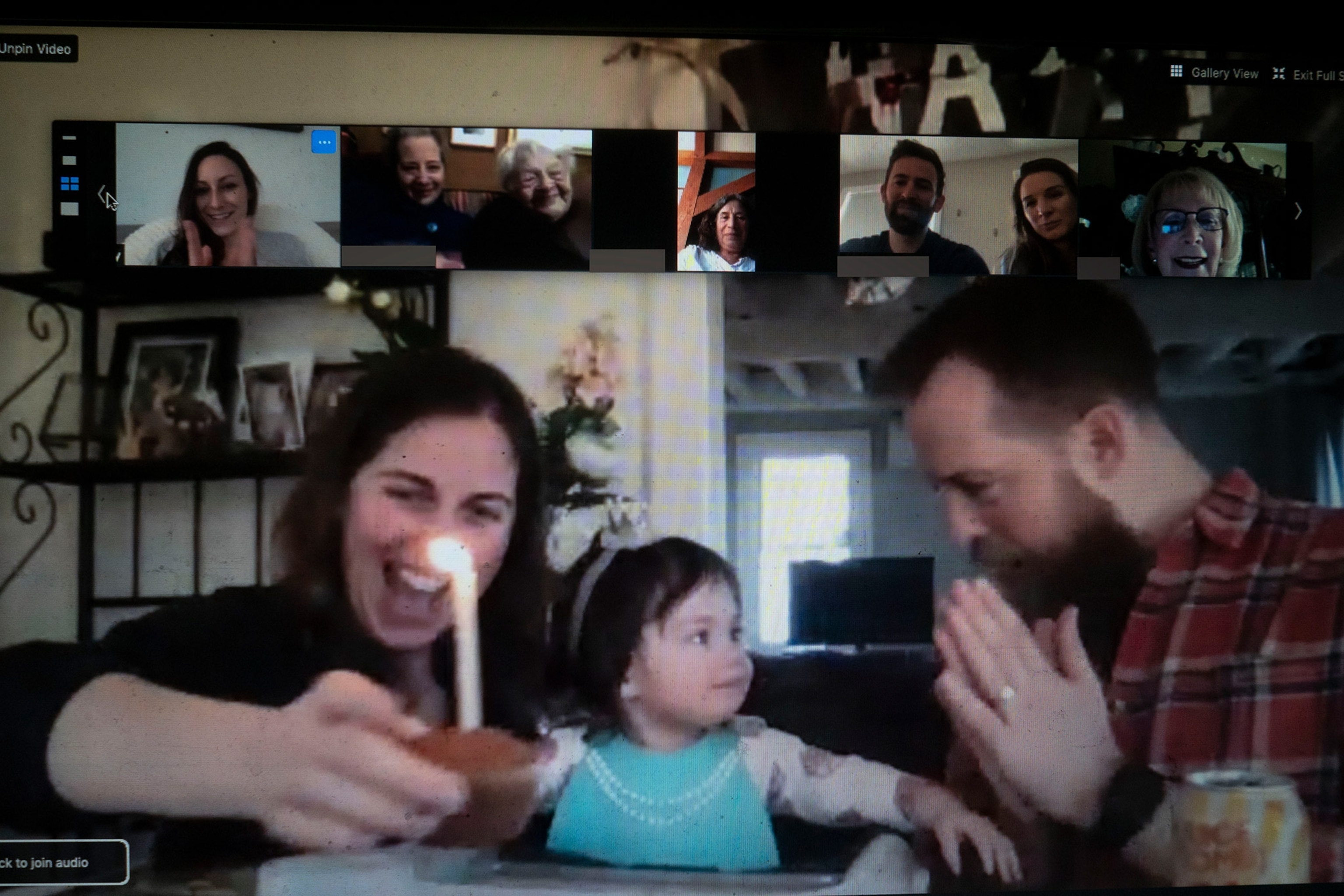 a family celebrating a birthday over a video call