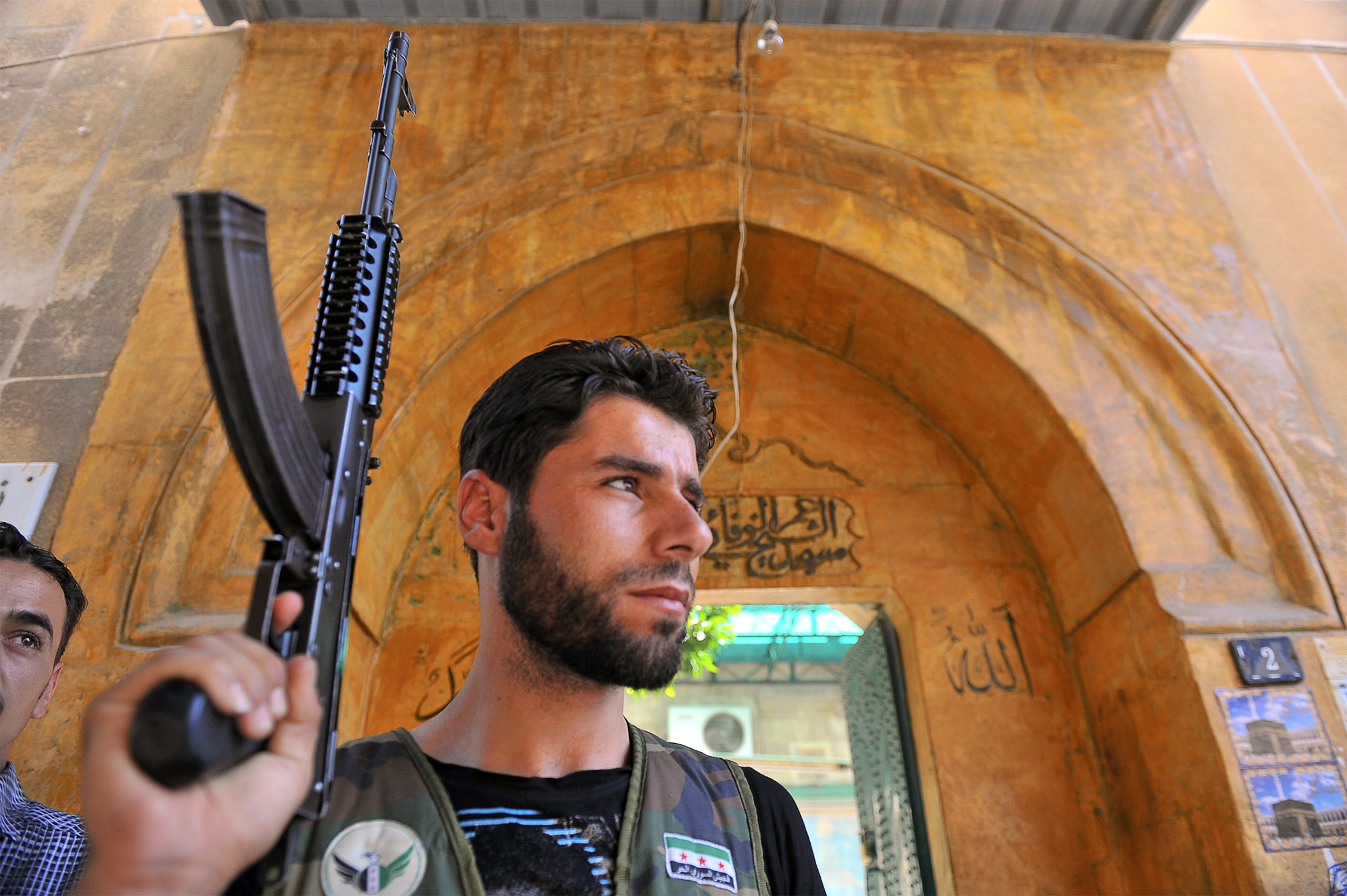 a rebel fighter at a gate in the old city of Aleppo