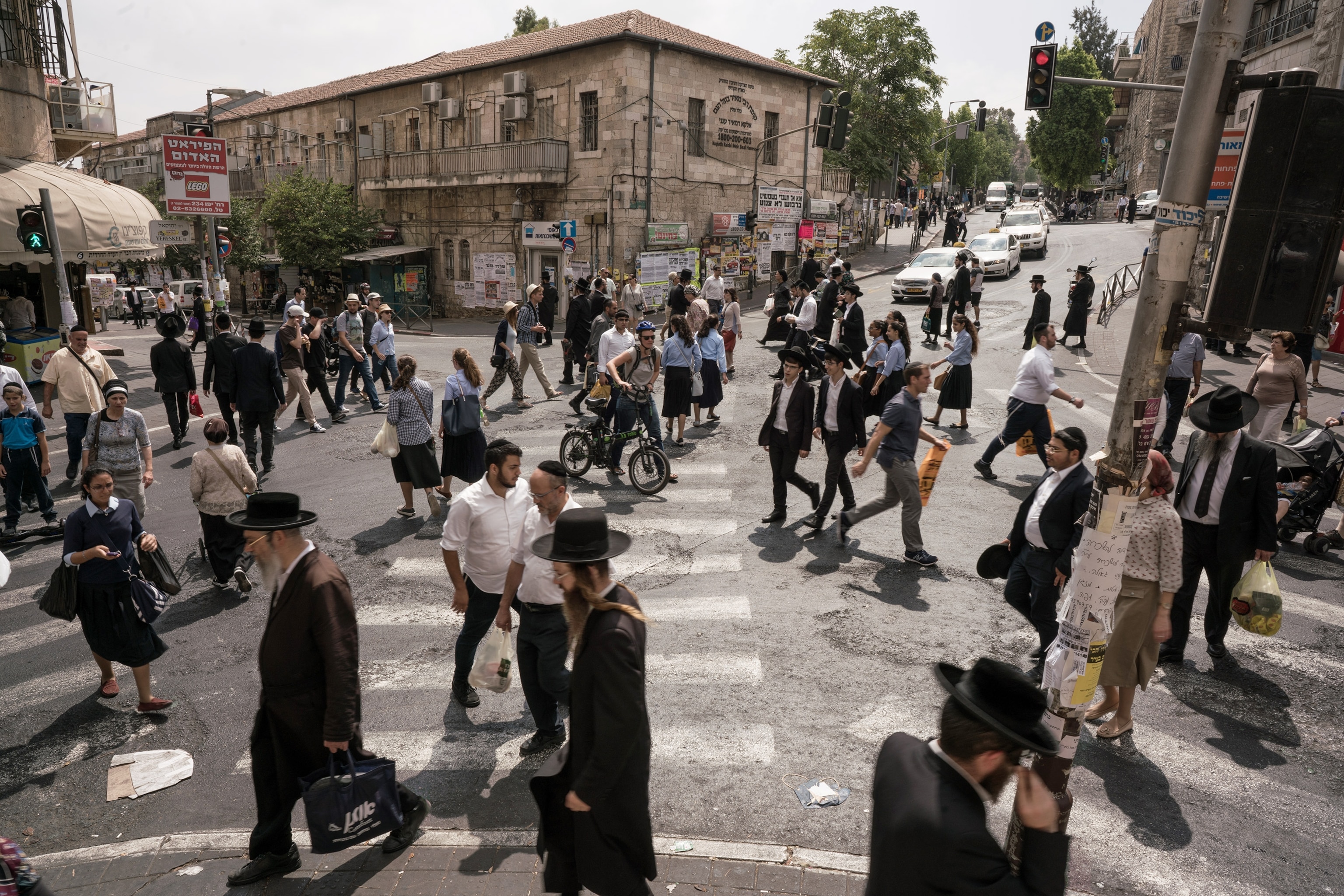 people crossing a main junction of the Ultra Orthodox neighbourhood in Jerusalem, Israel