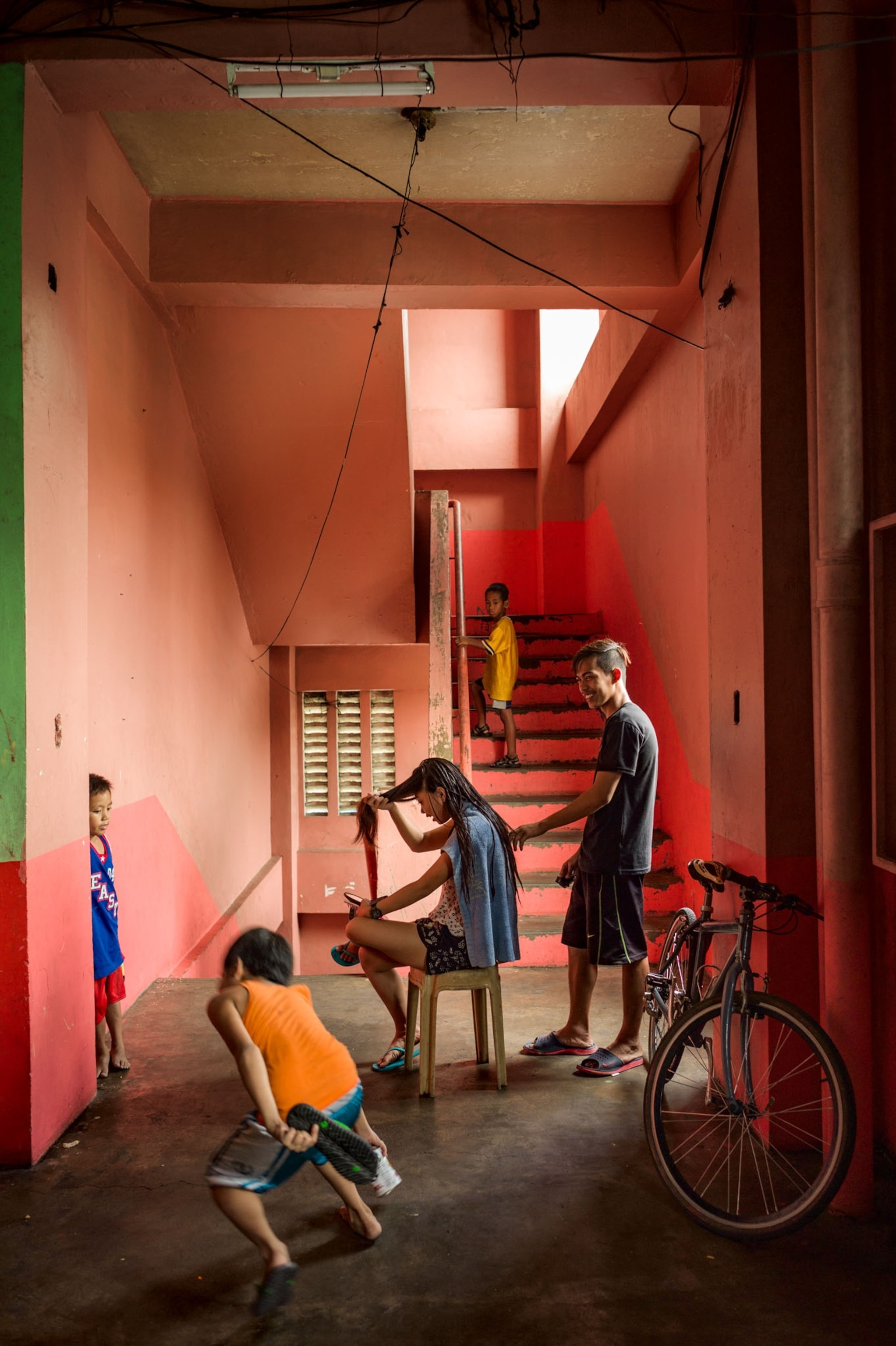 children playing in a red hallway and doing hair