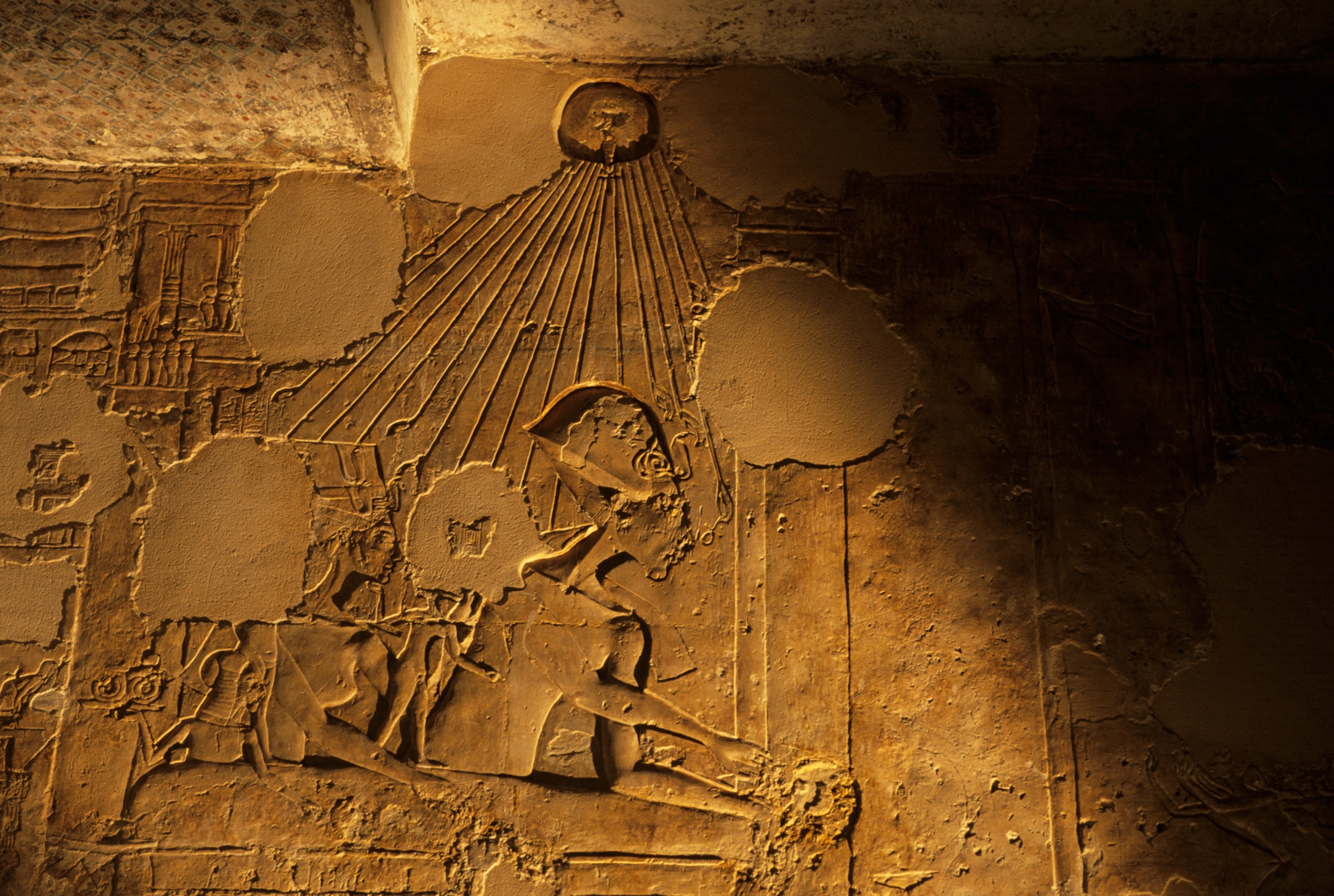 Ancient Egyptian relief showing a figure wearing a headdress, with sun rays extending towards