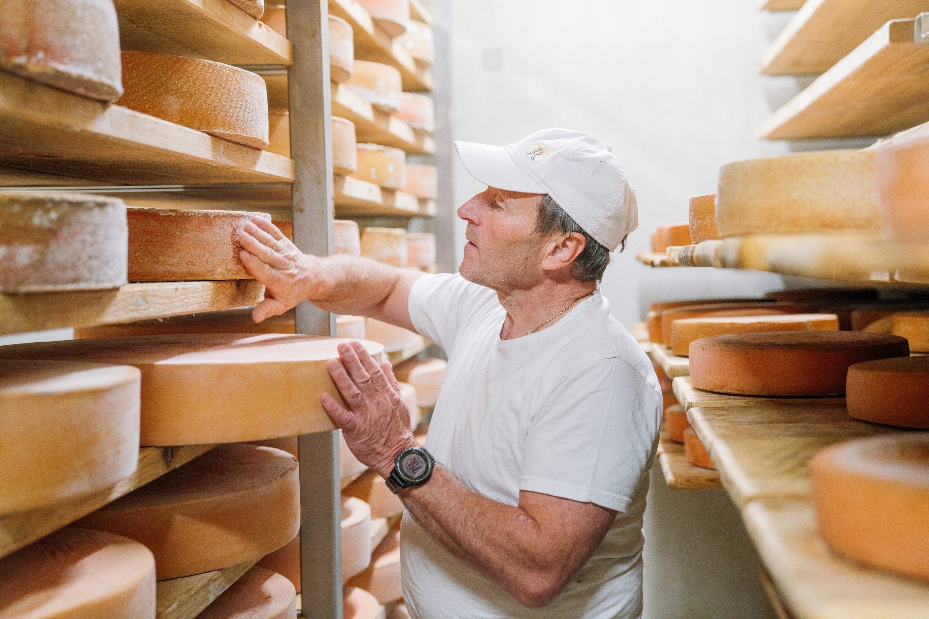 Hermann Huber checks the rind on his mountain cheese (bergkäse)