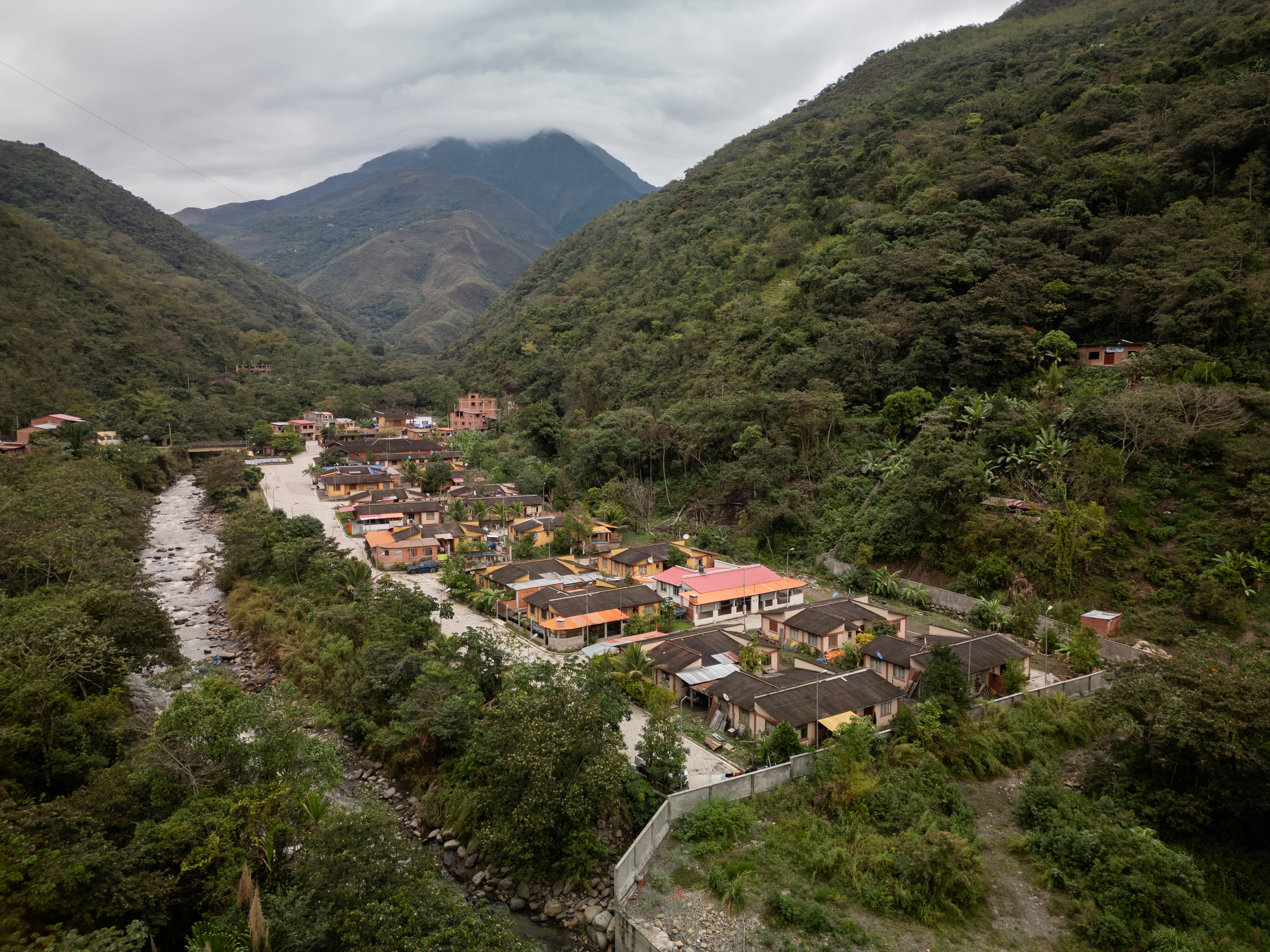 Aerial view of a small community tucked into lush green mountains.