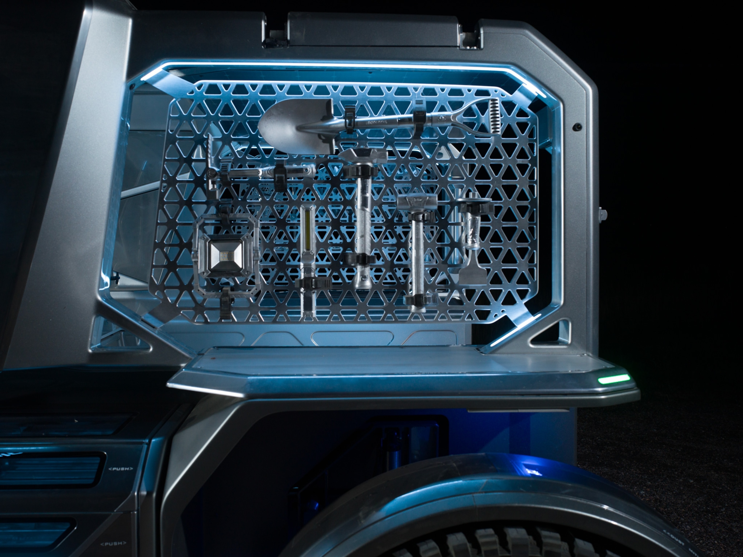 shovel and axe hanging on a steel enclosure on a 4x4 vehicle