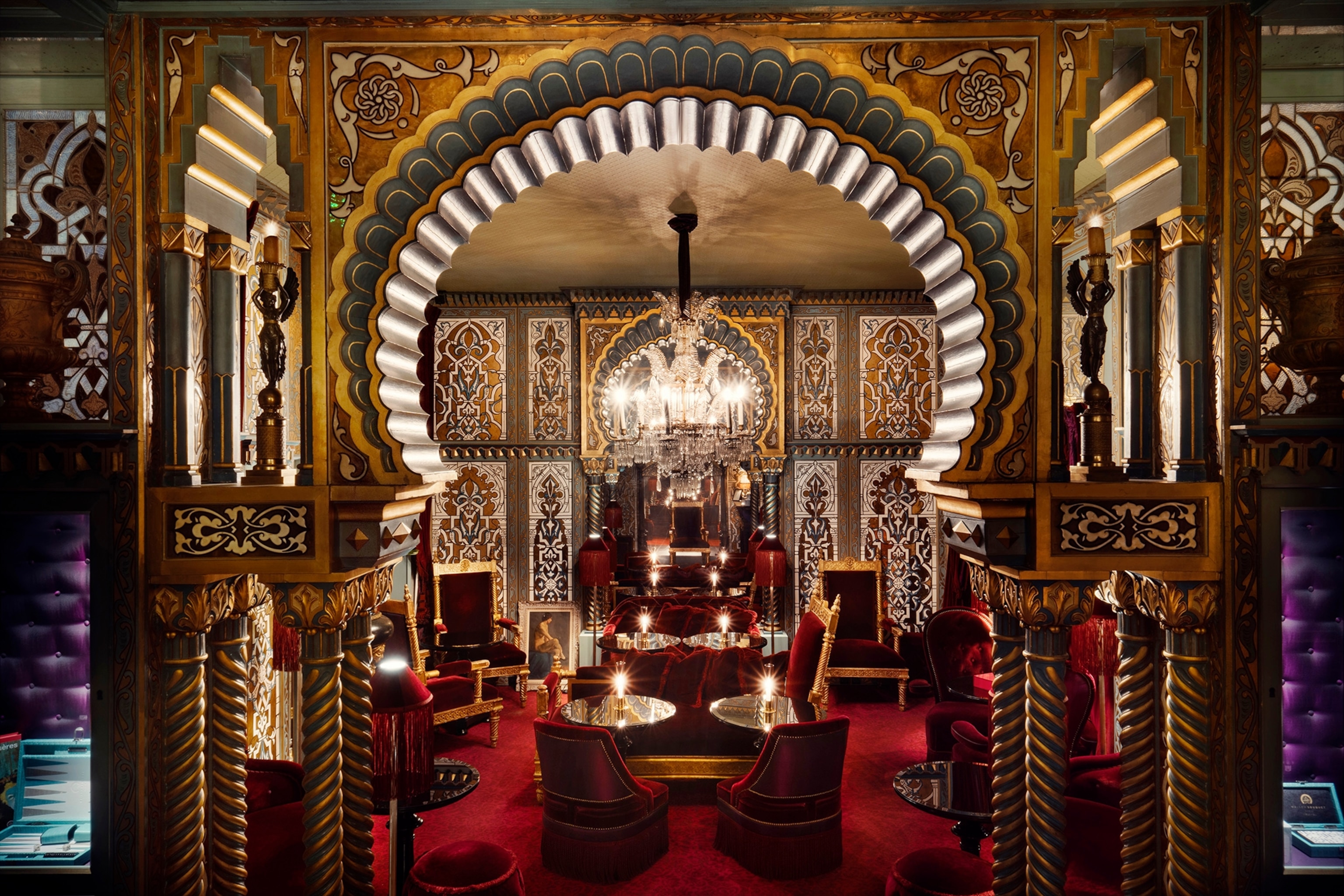 The interiors of a belle epoque bar with a half-circle arch and silk lamps.