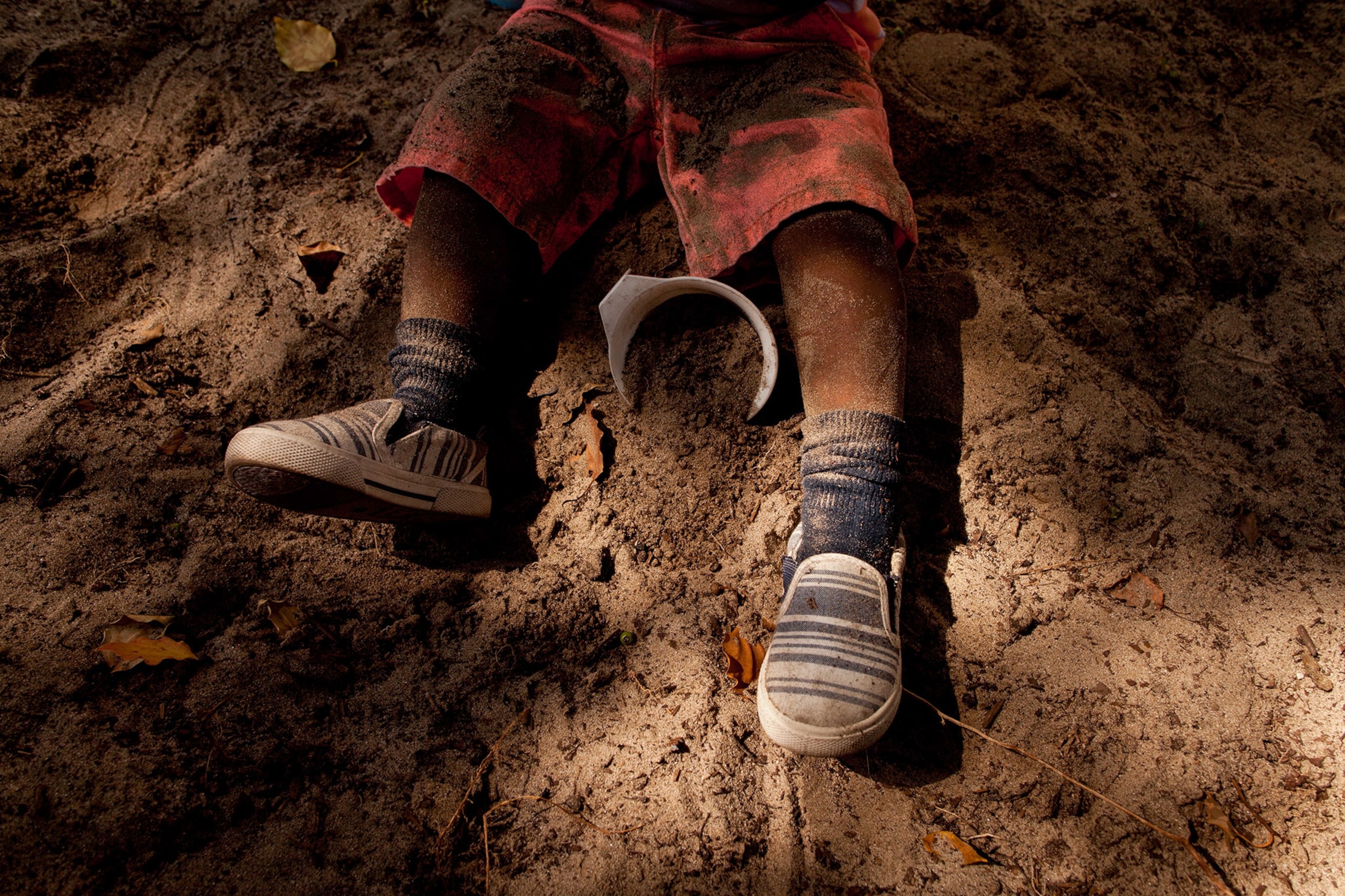a child's legs in the sandbox