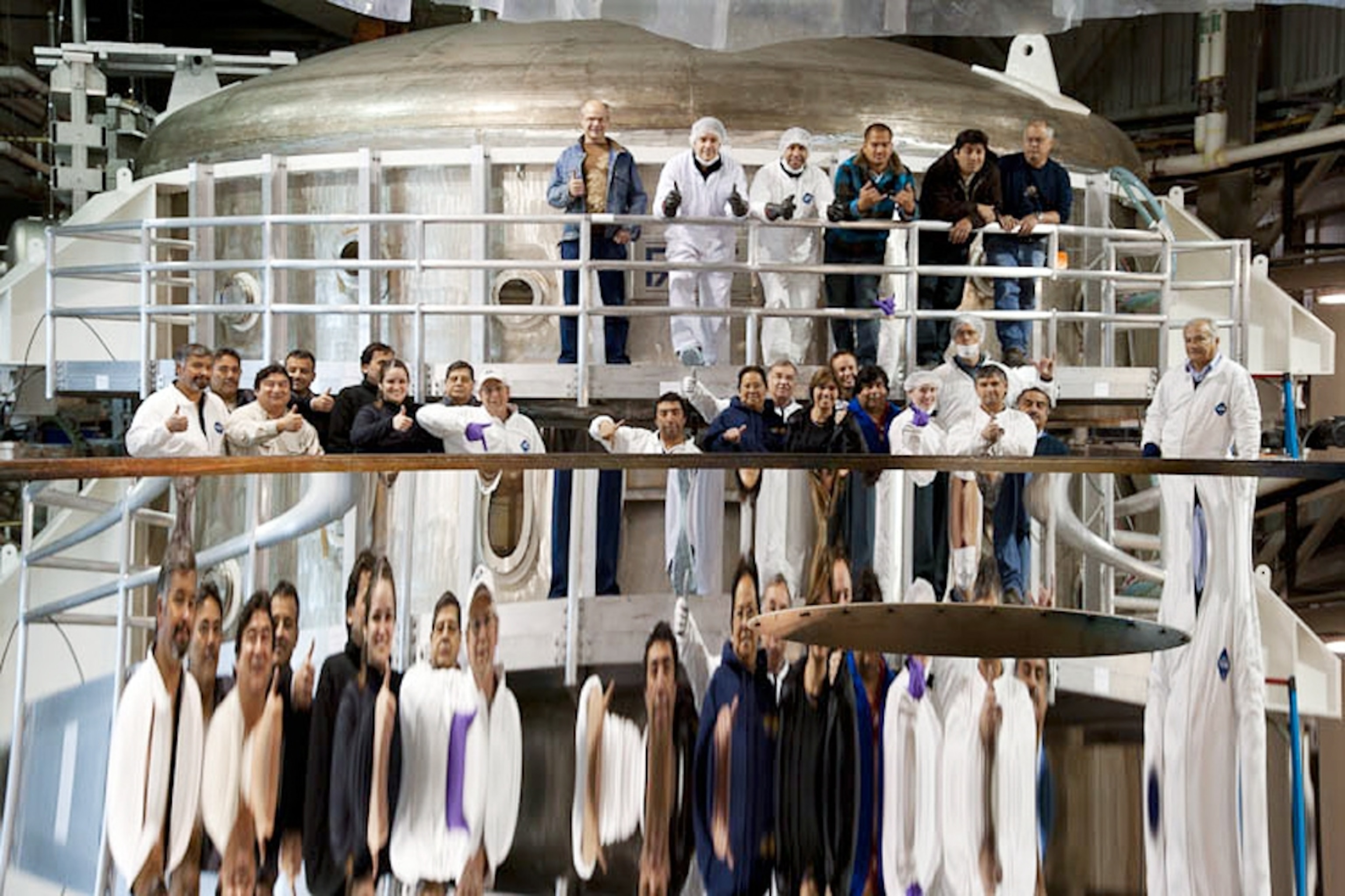 Picture of people reflected in a newly coated telescope mirror.