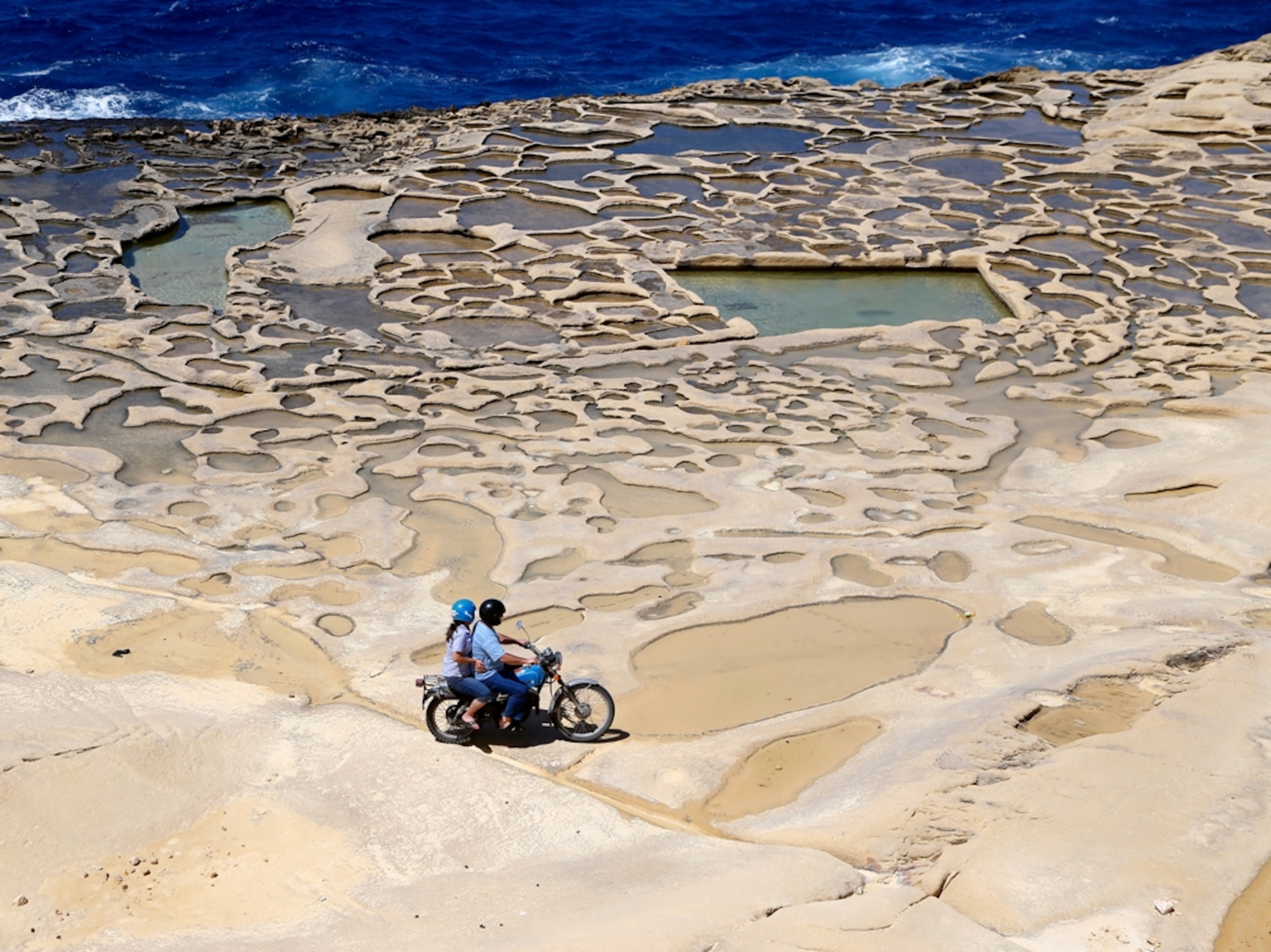 a couple on a motorcycle near the sea, Marsalforn, Gozo
