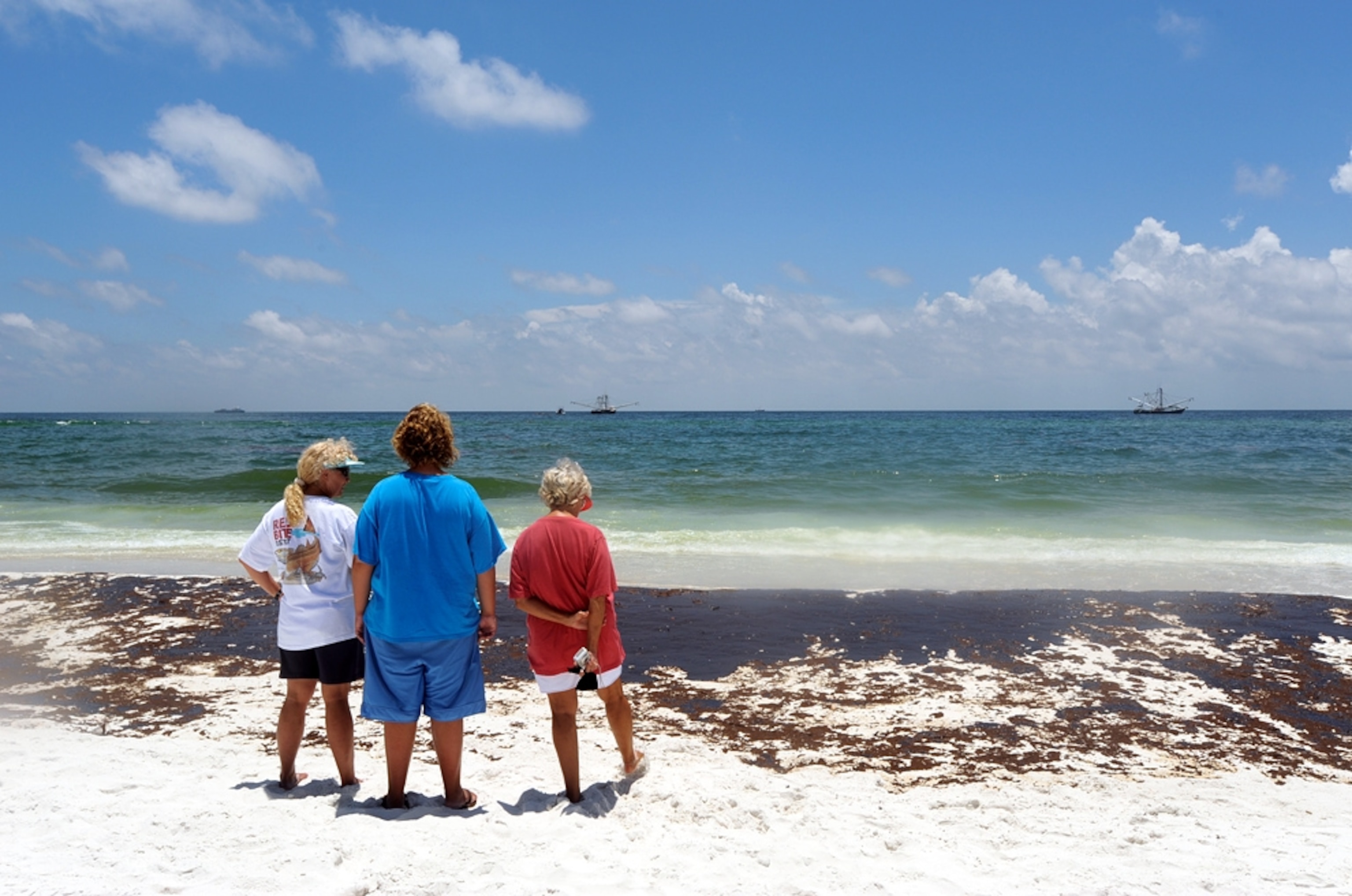 People look at oil from the Gulf oil spill on Pensacola Beach, Florida