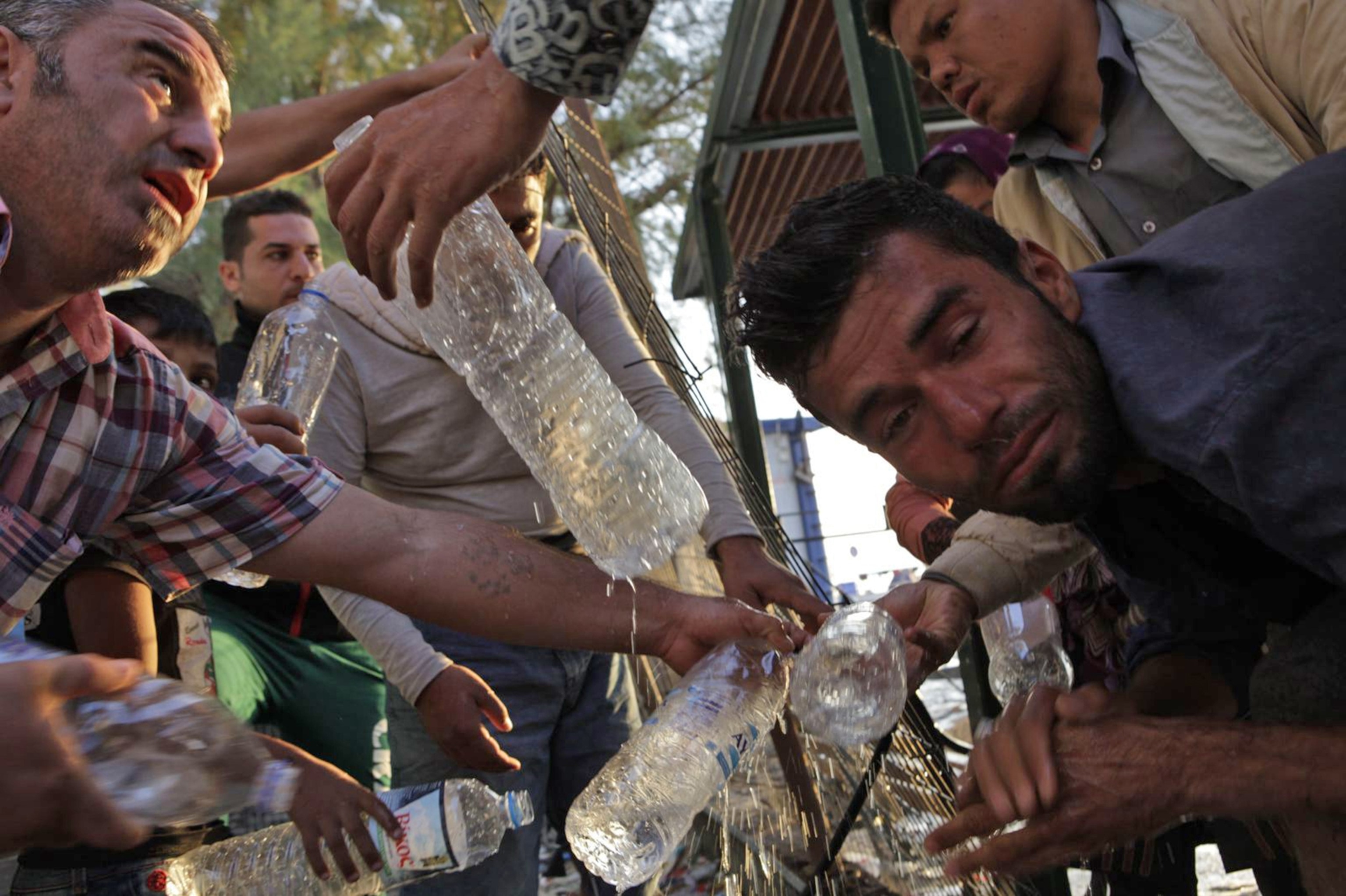 refugees cut a water supply line in order to wash and collect drinking water