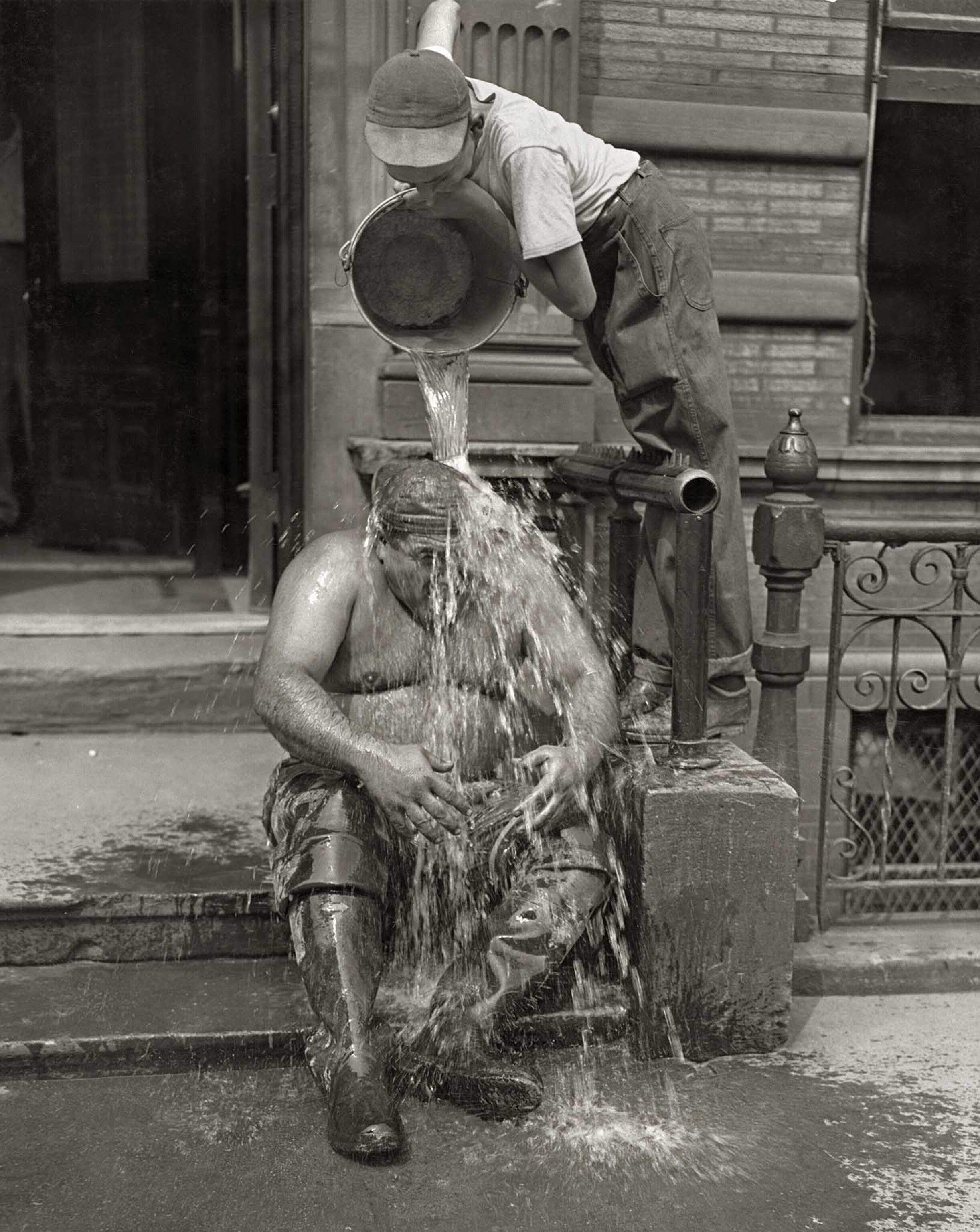 a construction worker getting a refreshing bucket of water poured over him
