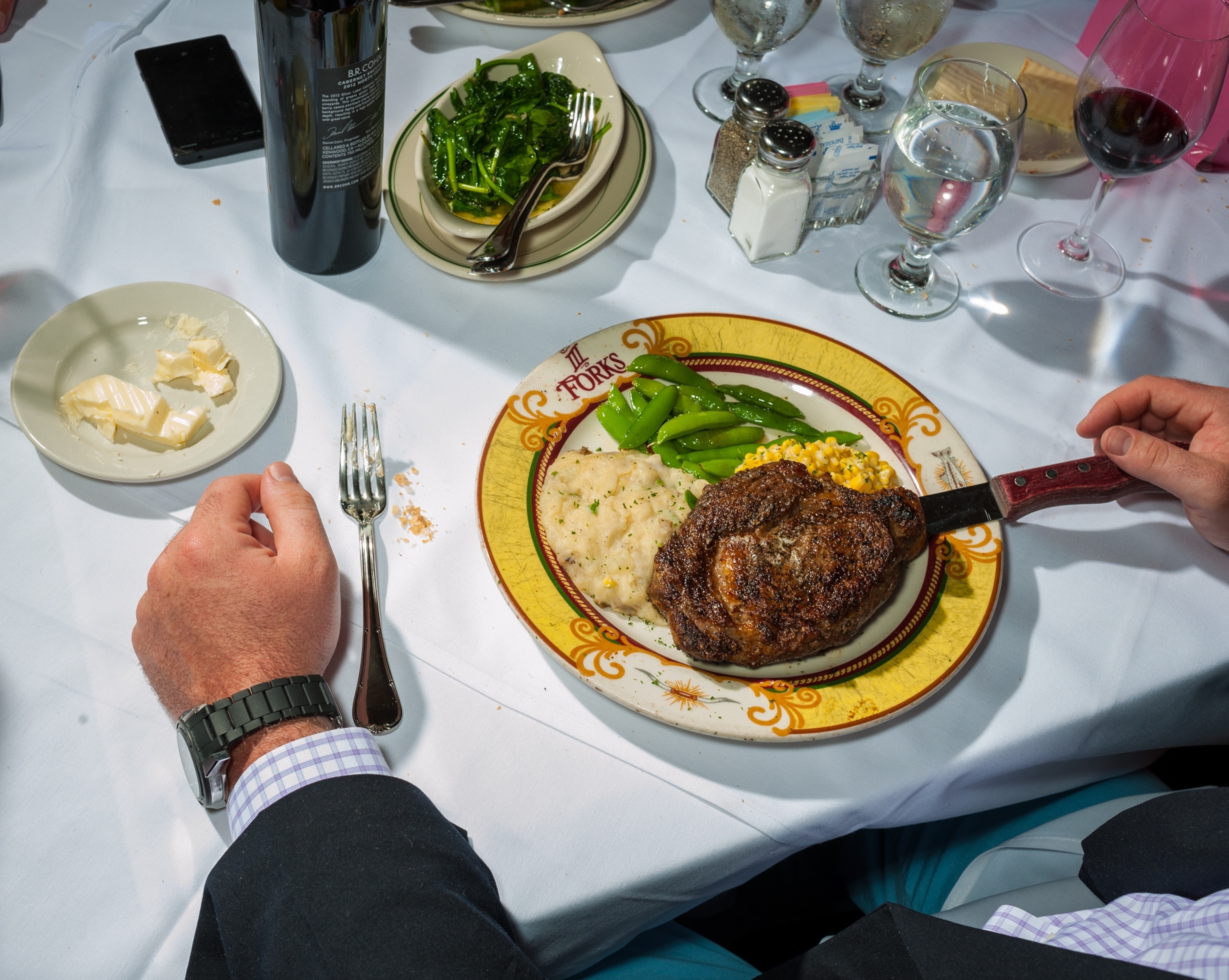 a man sitting in front of a steak dinner