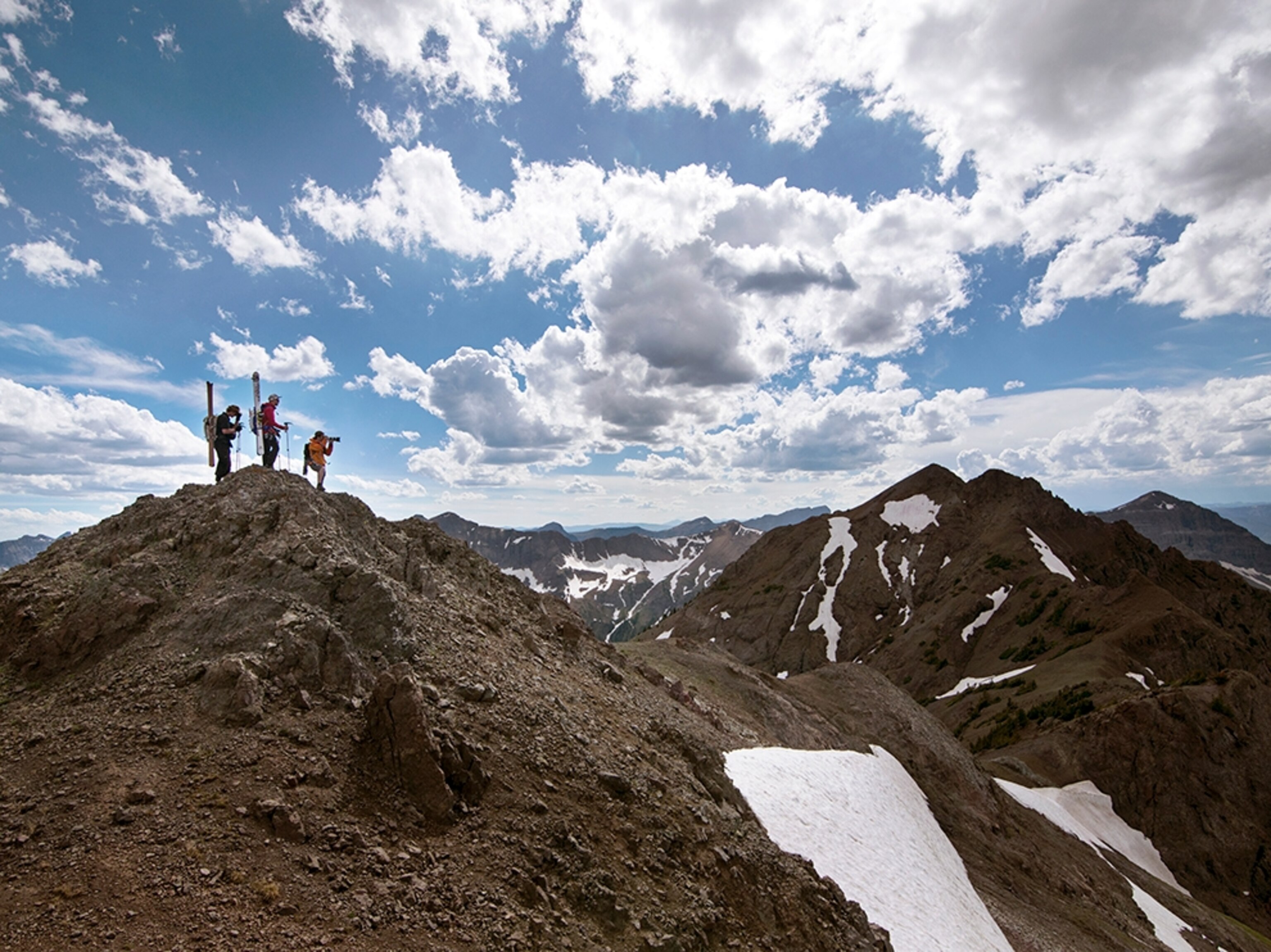 three hikers on a peak in the Beartooth Mountains, Montana