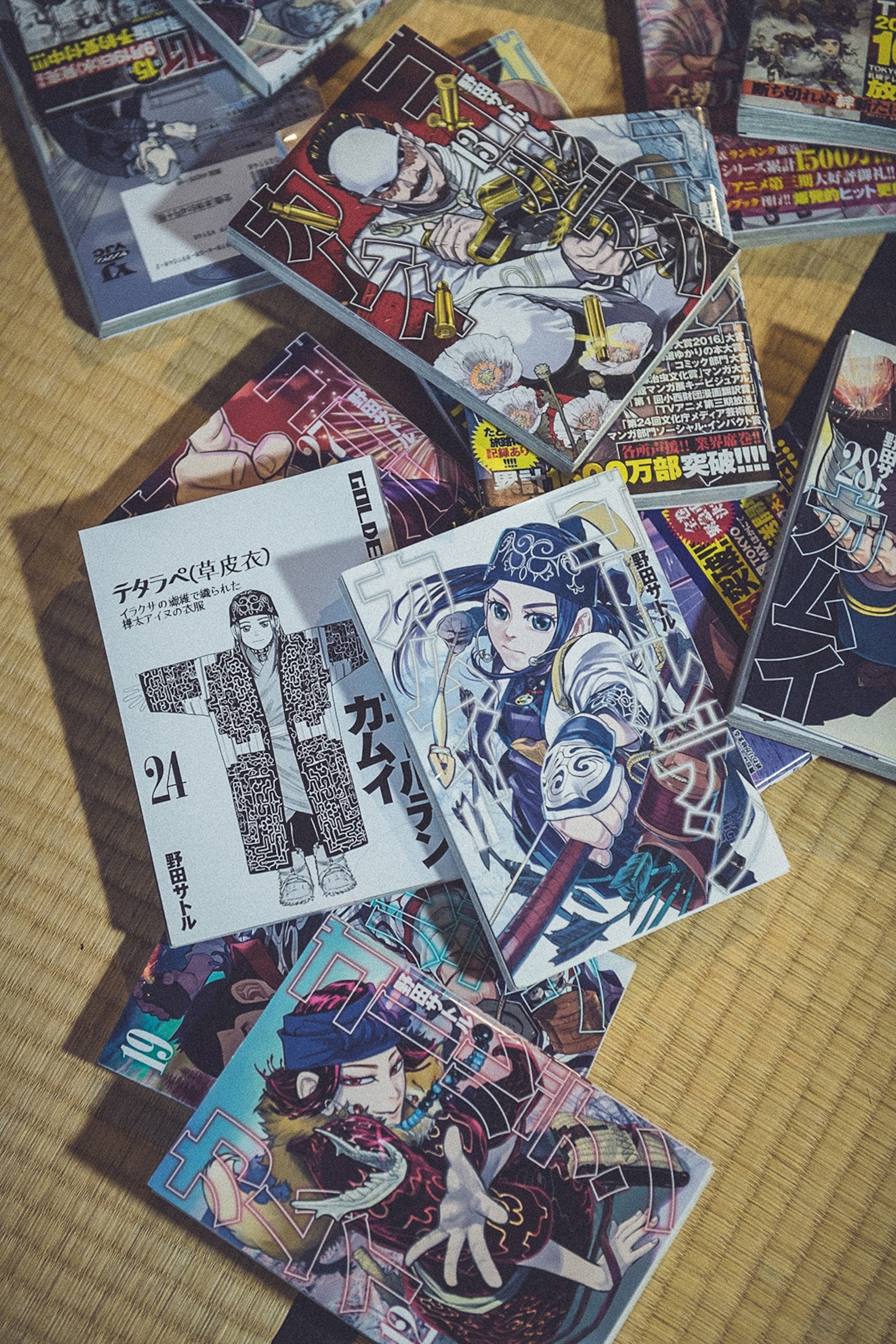 A traditional tatami floor with multiple manga comics scattered cross it.