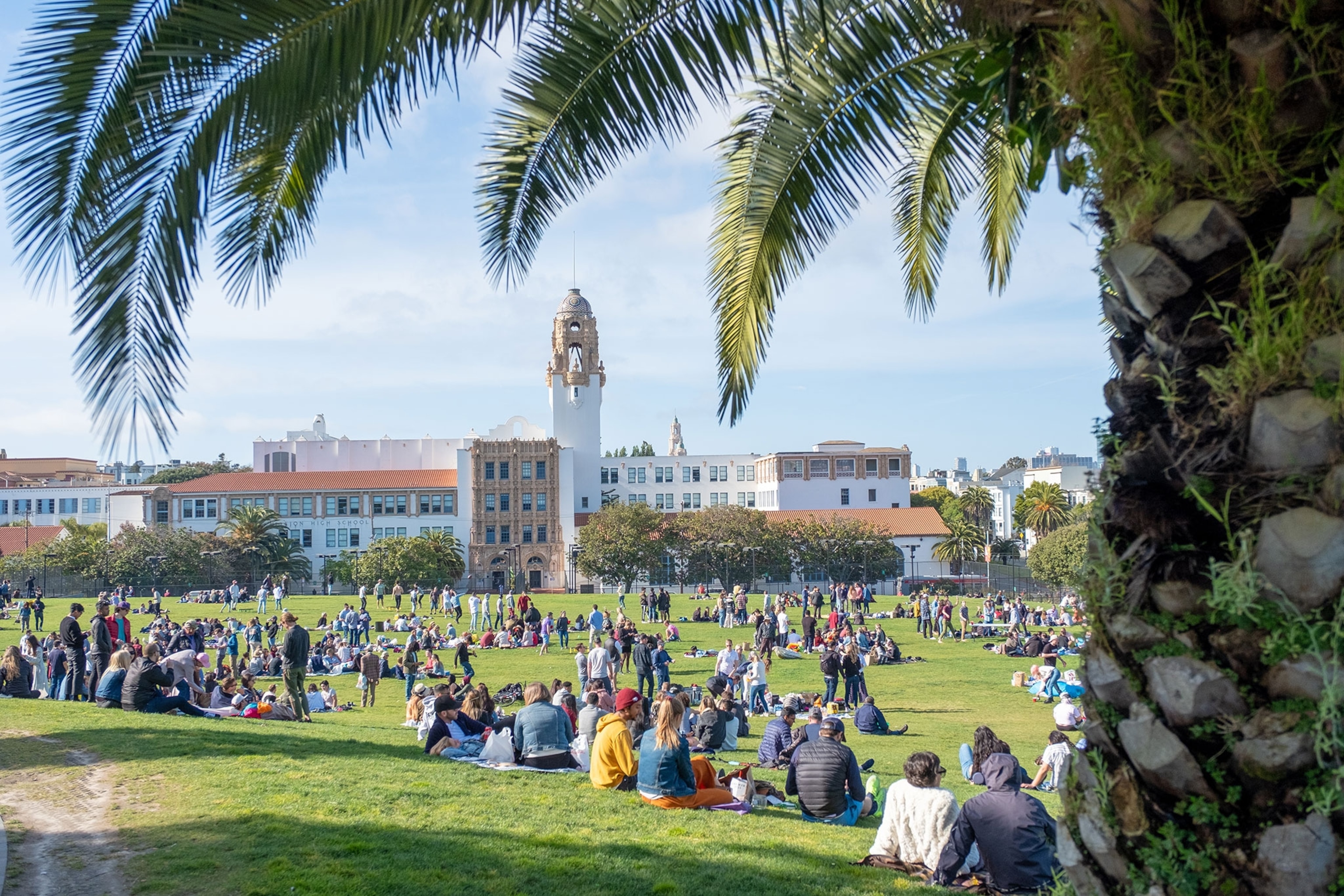 A crowds of people sit on a lawn.