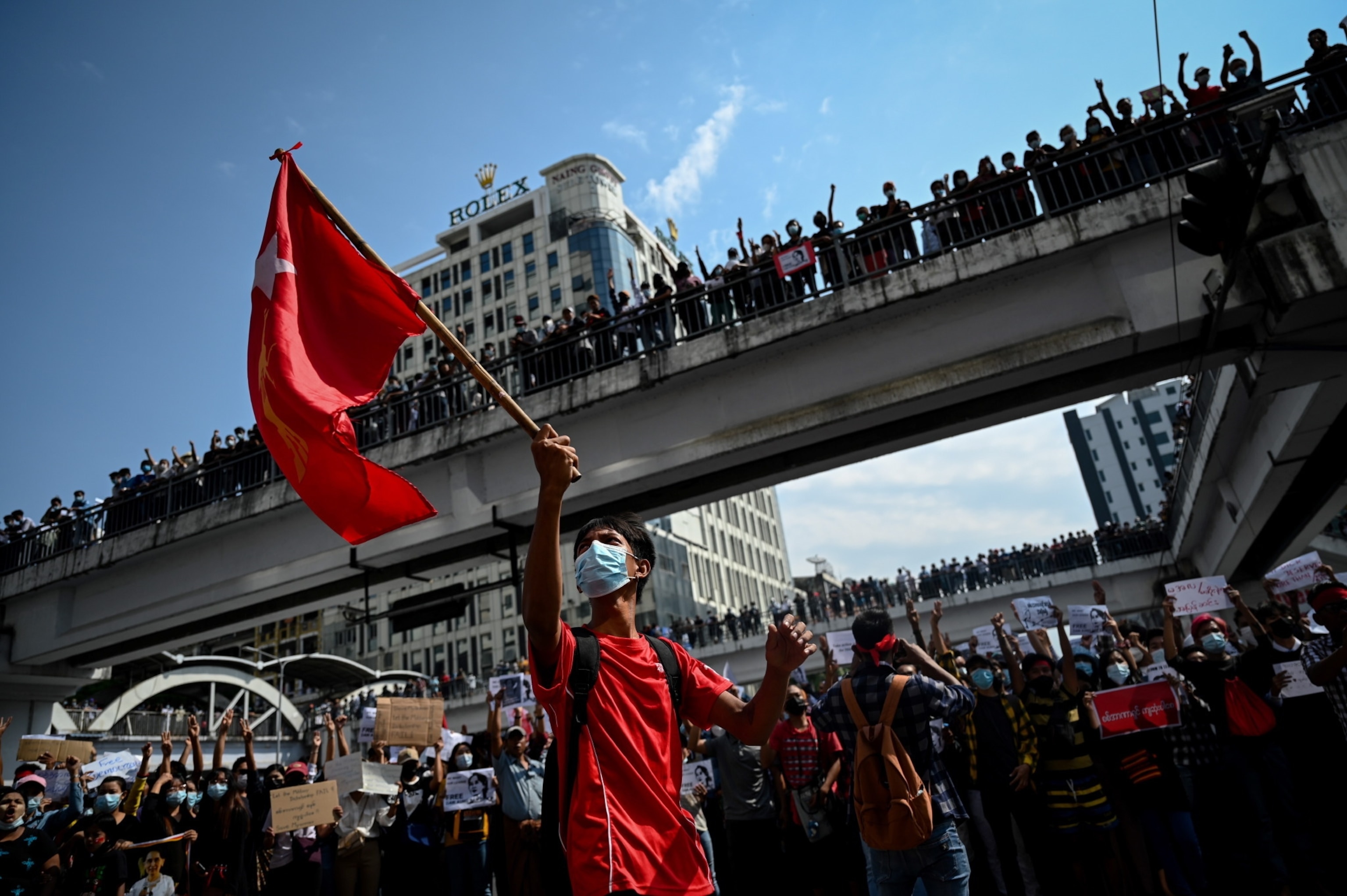 A person waves a flag in front of a large crowd