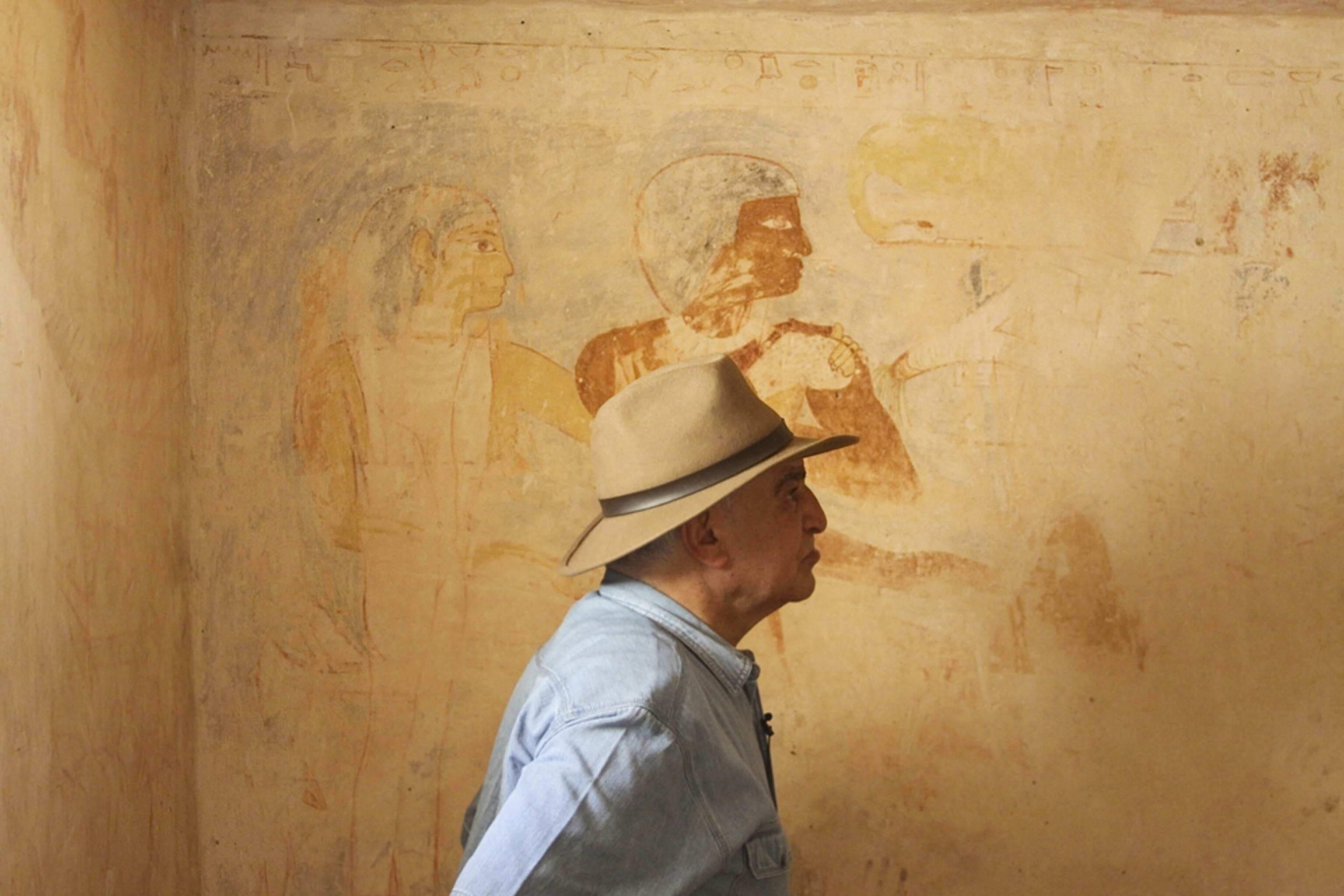 Picture of Zahi Hawass standing in front of tomb artwork.