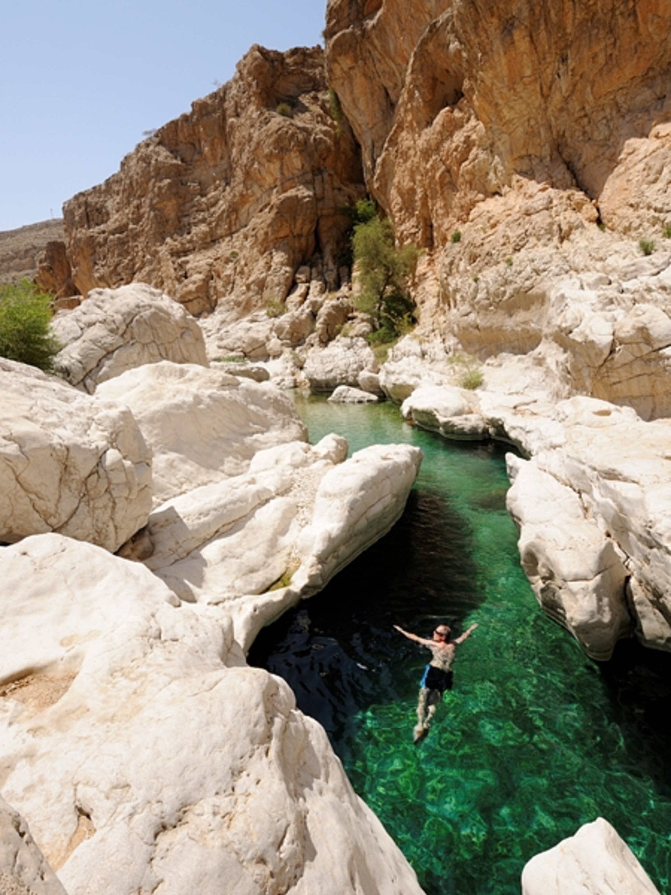 Man jumping into water in Oman