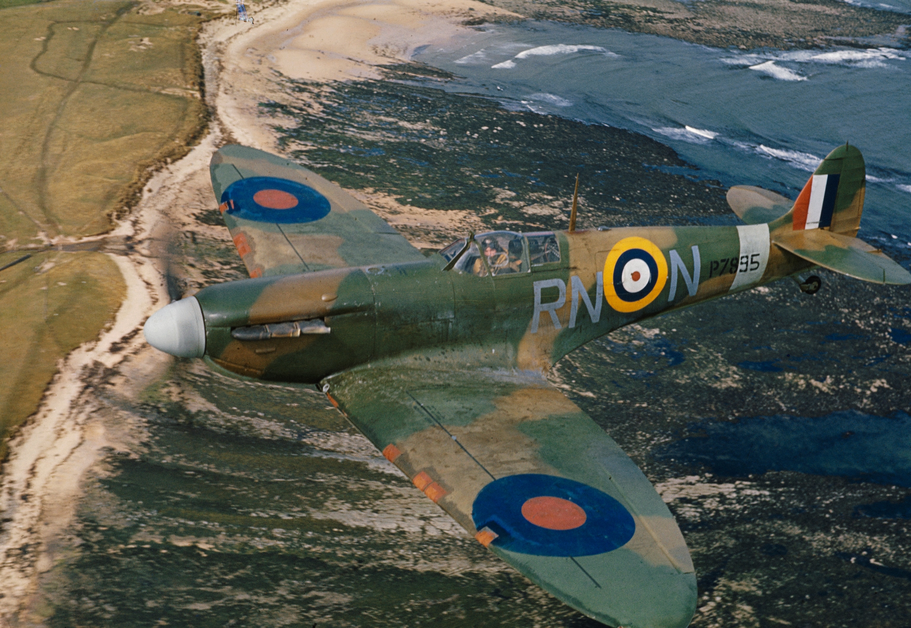 A Supermarine Spitfire Mark IIA, P7895 'RN-N', piloted by Flight Lieutenant R Deacon Elliot of No 72 Squadron, based at RAF Acklington, Northumberland, flies over the coast, Britain, 1941.