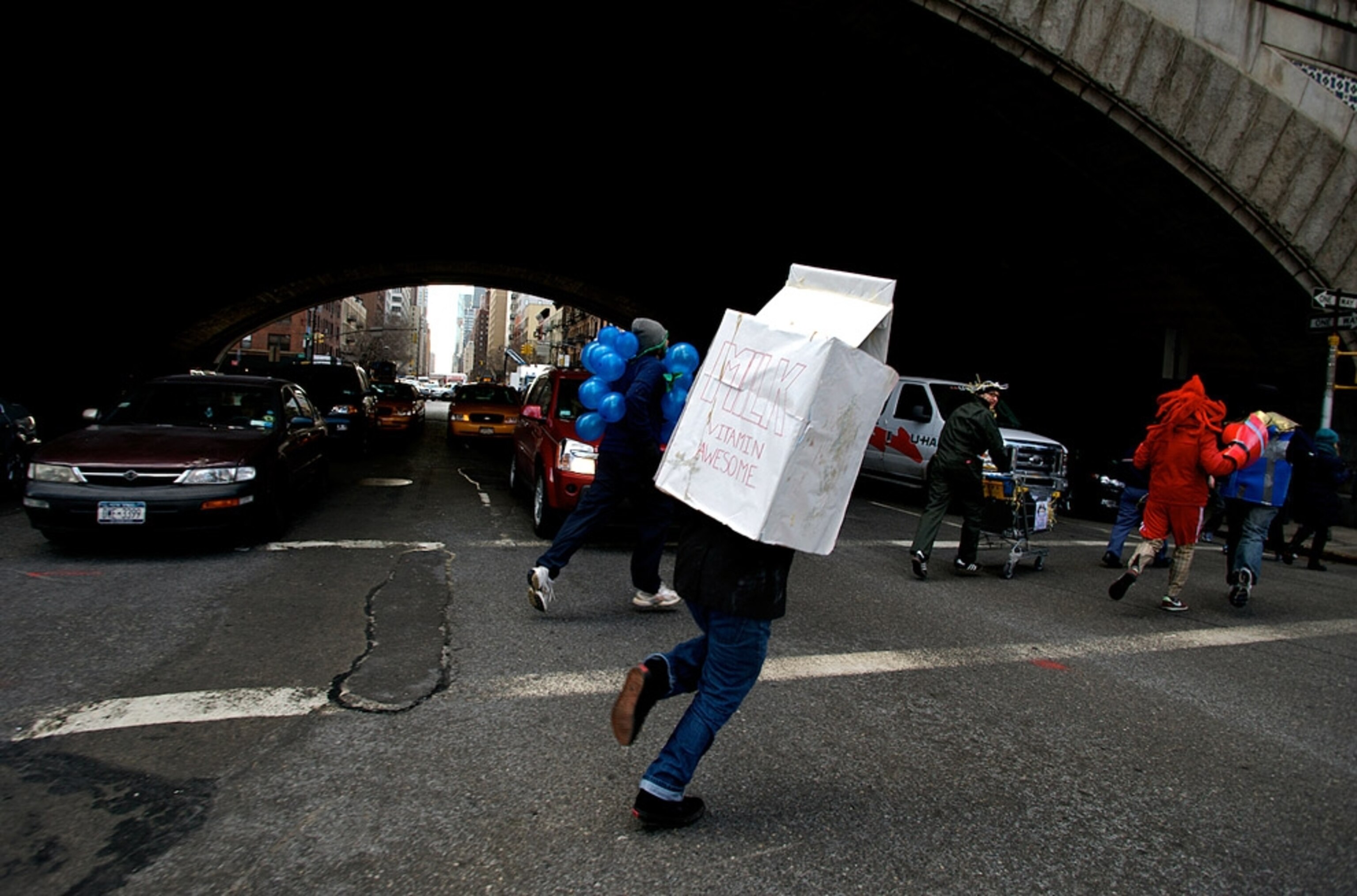 Person dressed as milk carton runs under overpass