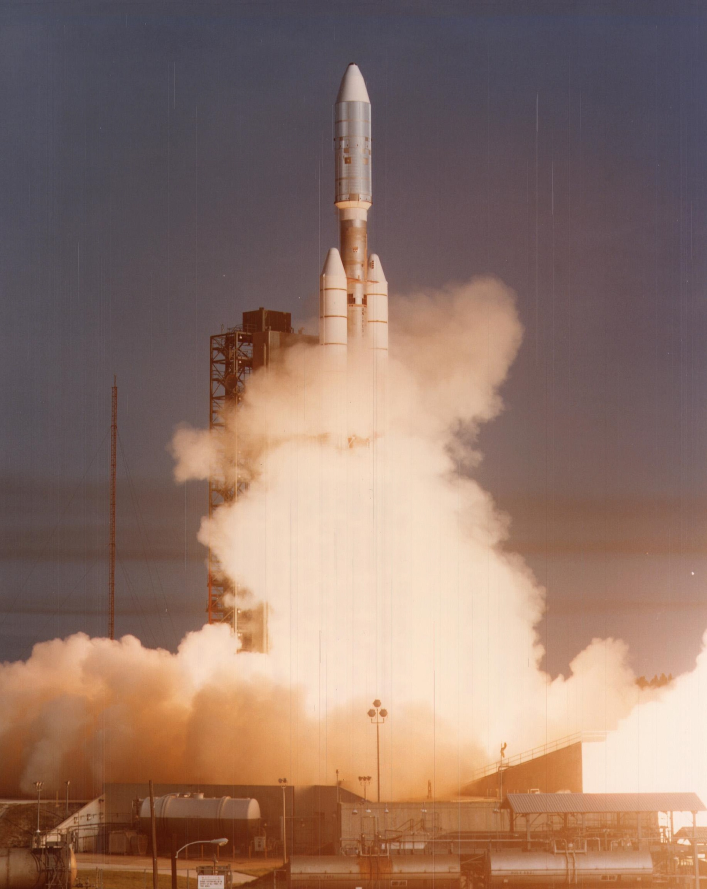 A silver rocket surrounded by the golden glow of flames as it launches