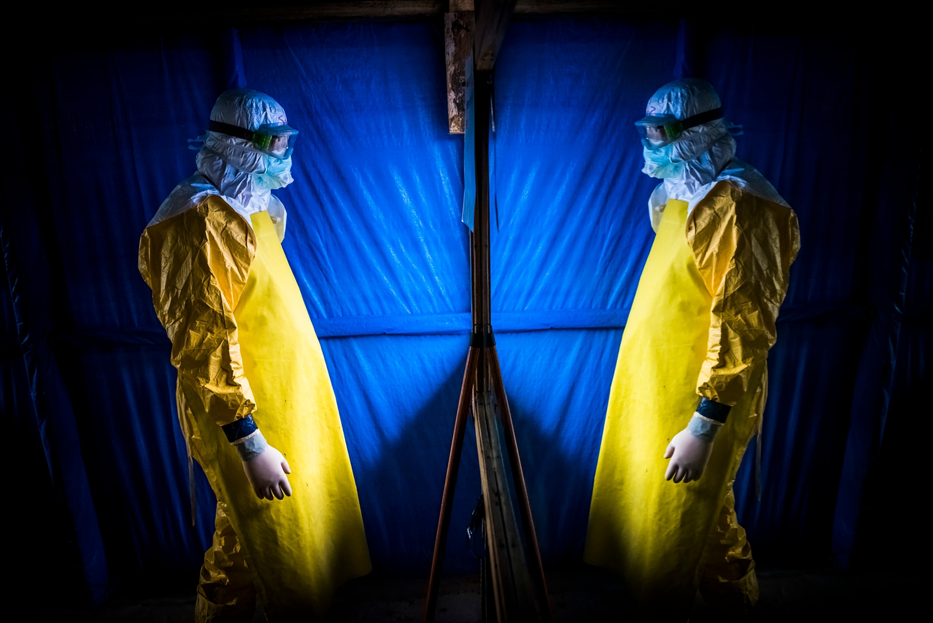 Dr. Steven Hatch checks his protective gear in a mirror before entering a high-risk ward at an Ebola clinic run by the International Medical Corps near in Suakoko, Liberia, Oct. 13, 2014.