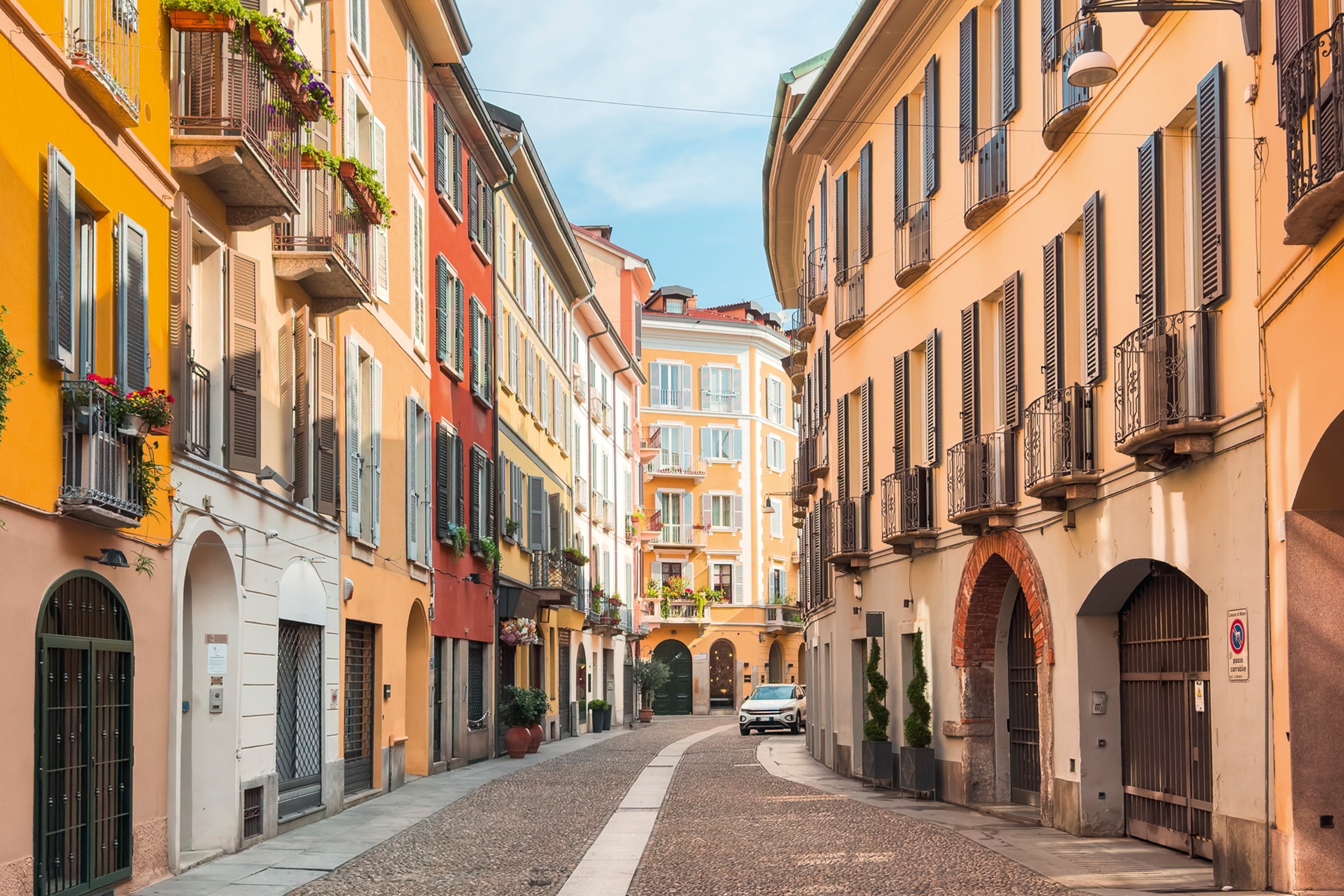 A typical cobblestone street in the center of Milan with residential houses lining either side.