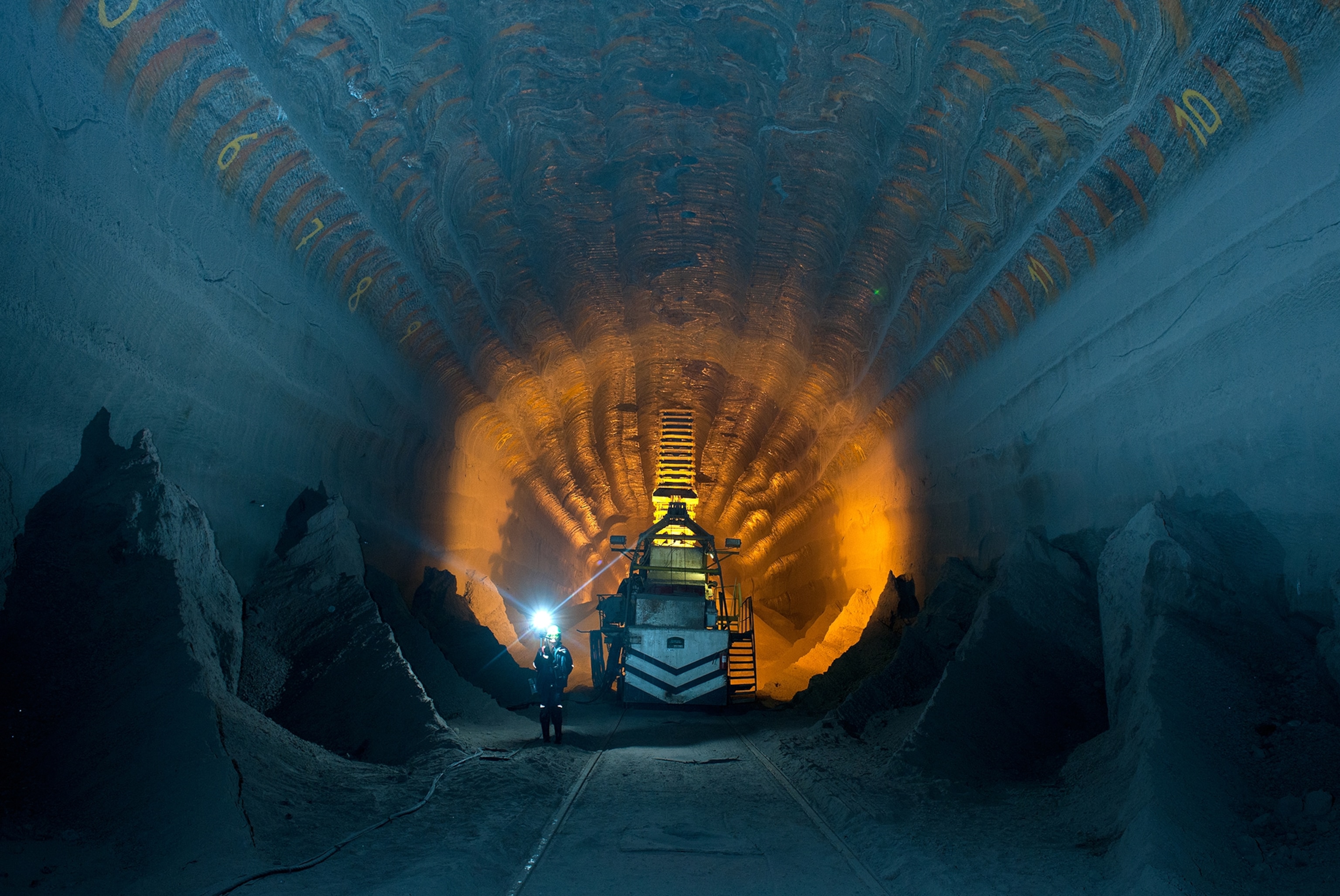 a man wearing a headlamp standing in a salt mine