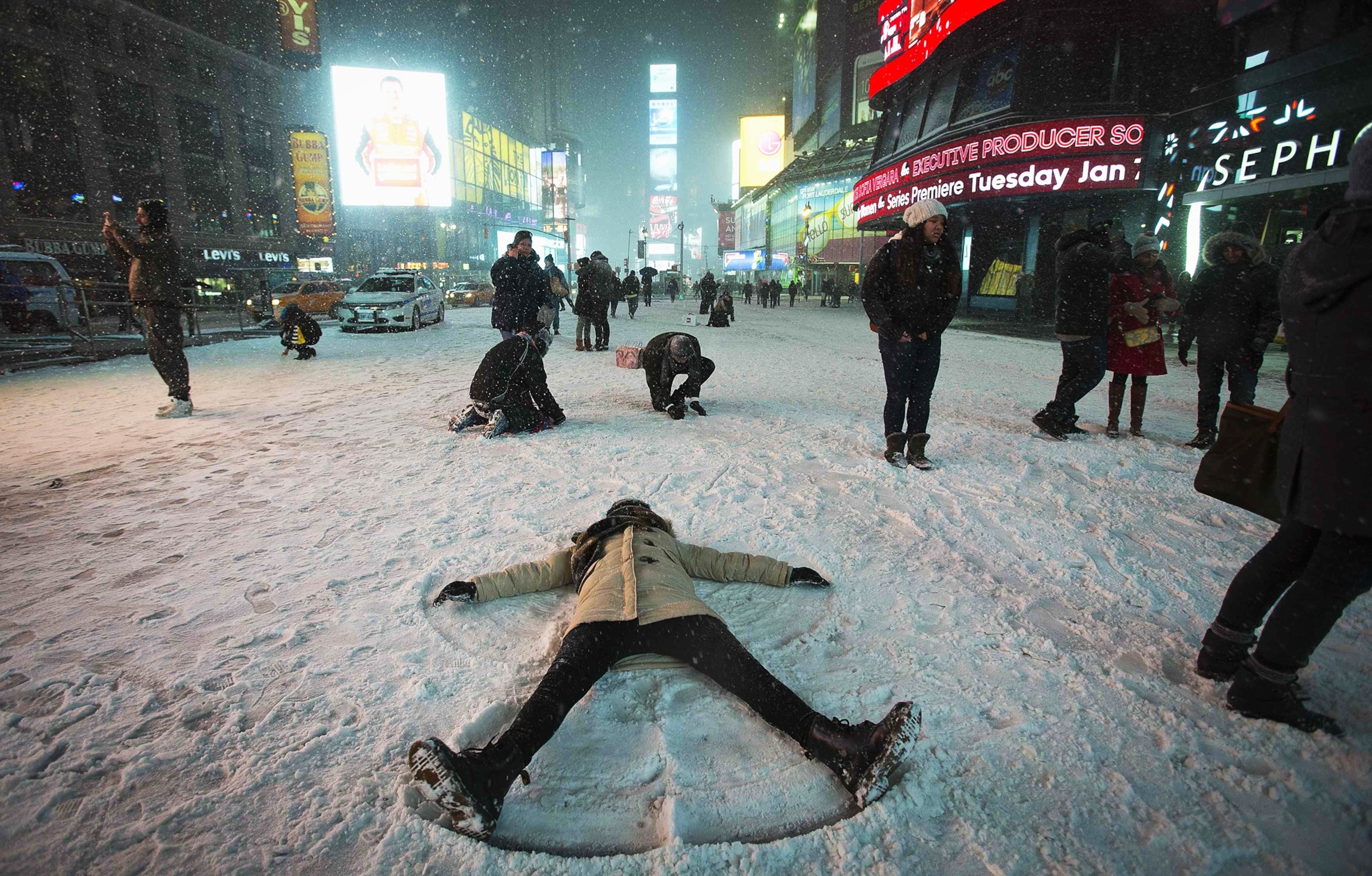 a person making a snow angel in Times Square in New York City on Friday