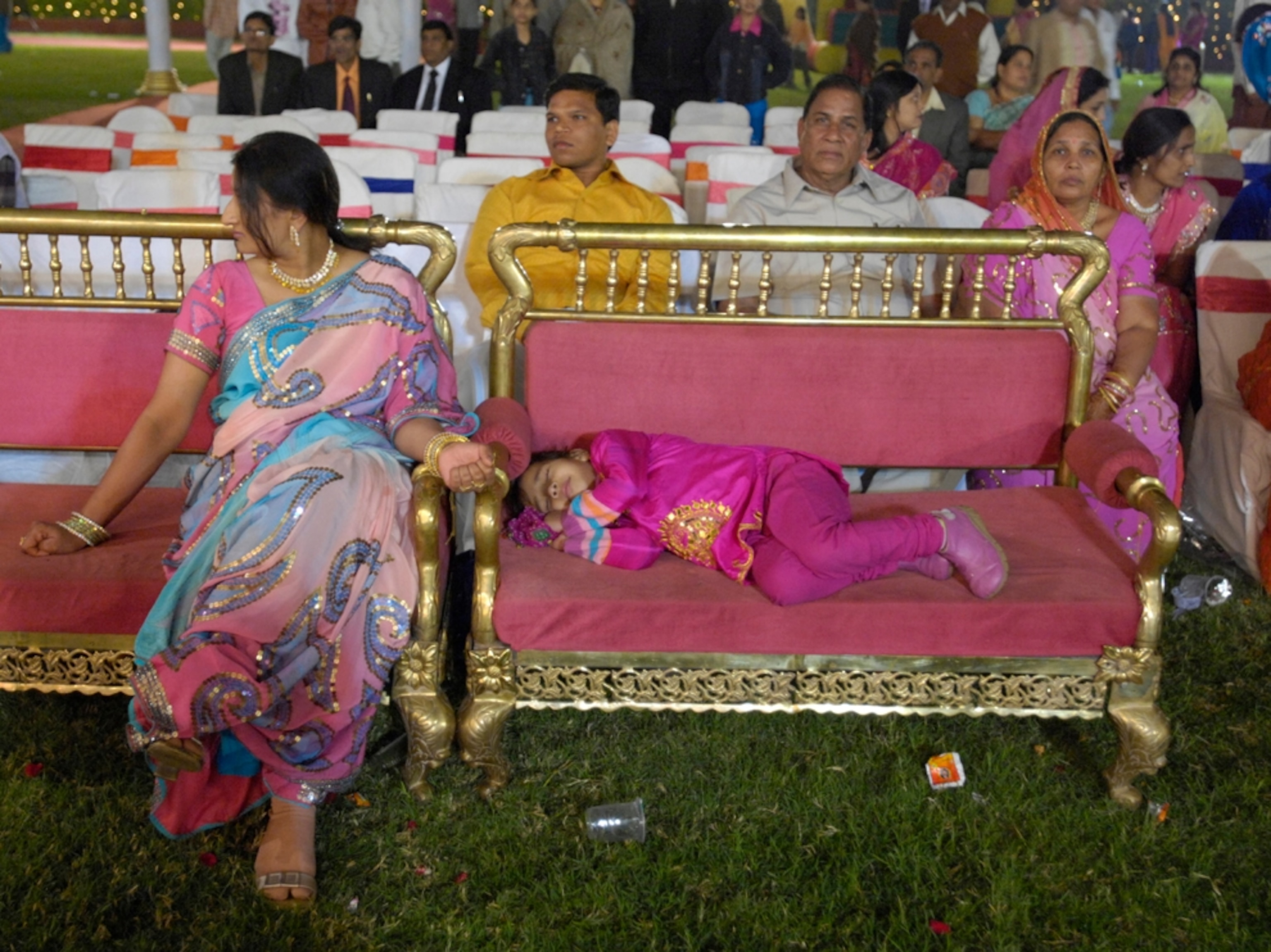Child naps at wedding reception, India