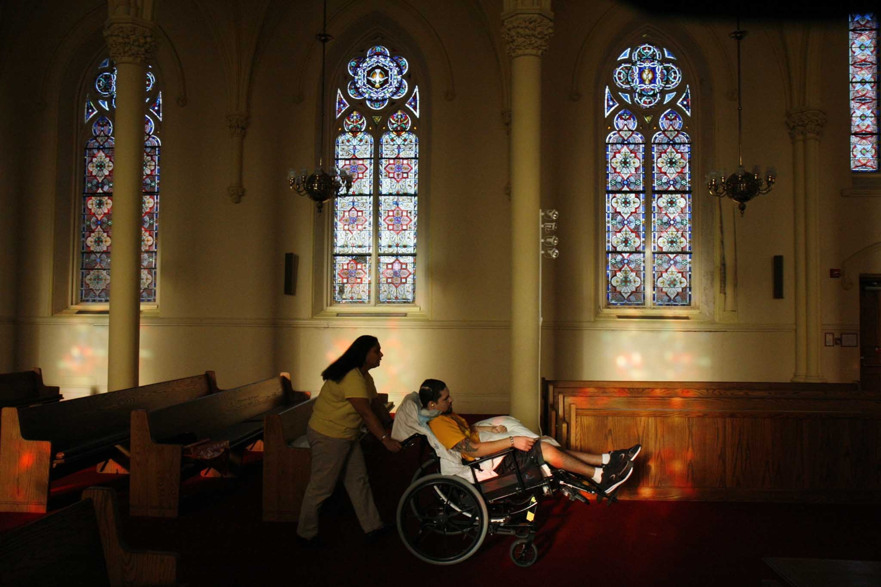 Maria Mendez, aunt of Roberto Reyes, wheels him into the chapel at the VA hospital in the Bronx.