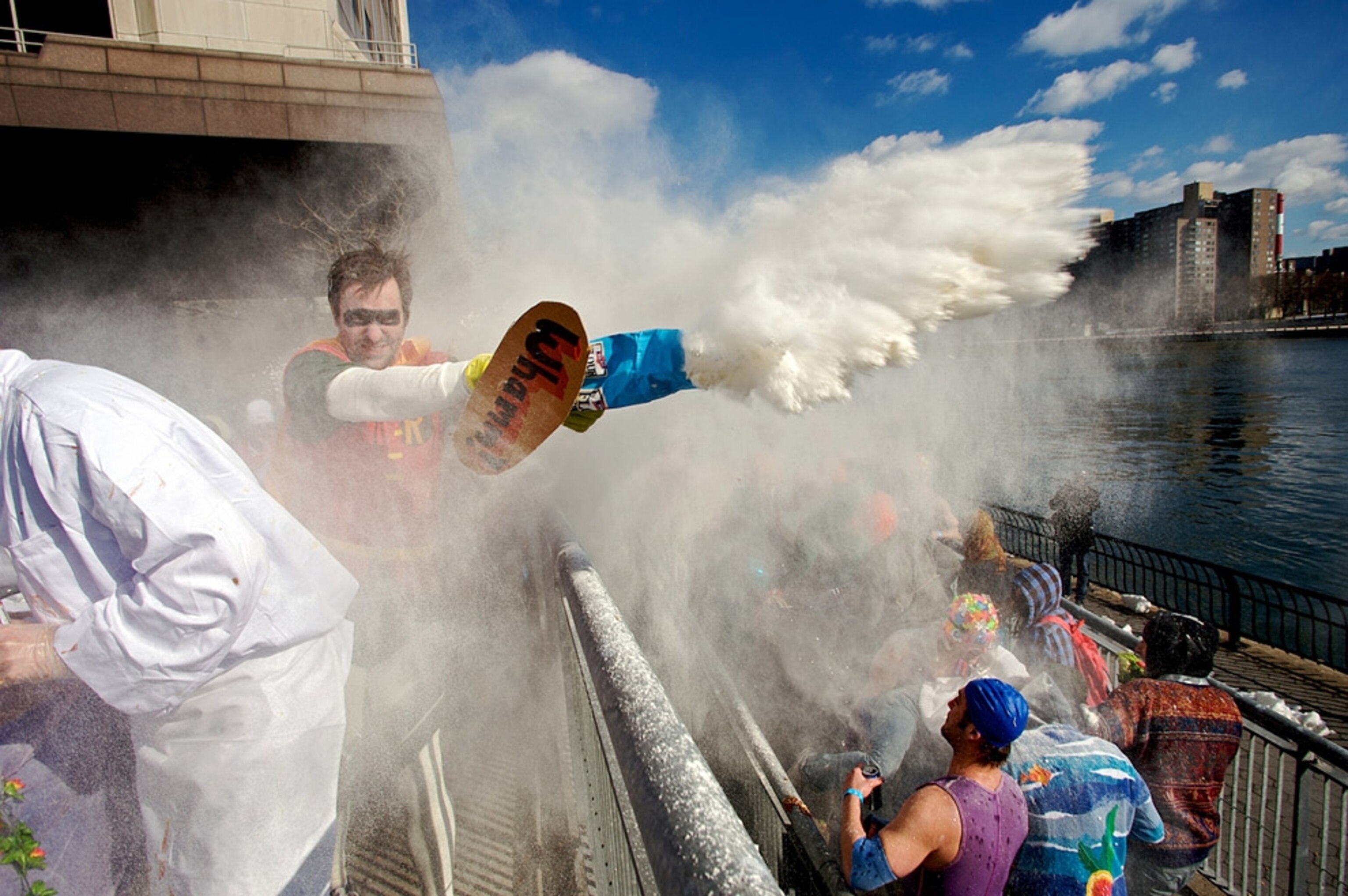 Man dressed as Robin throwing flour on racers