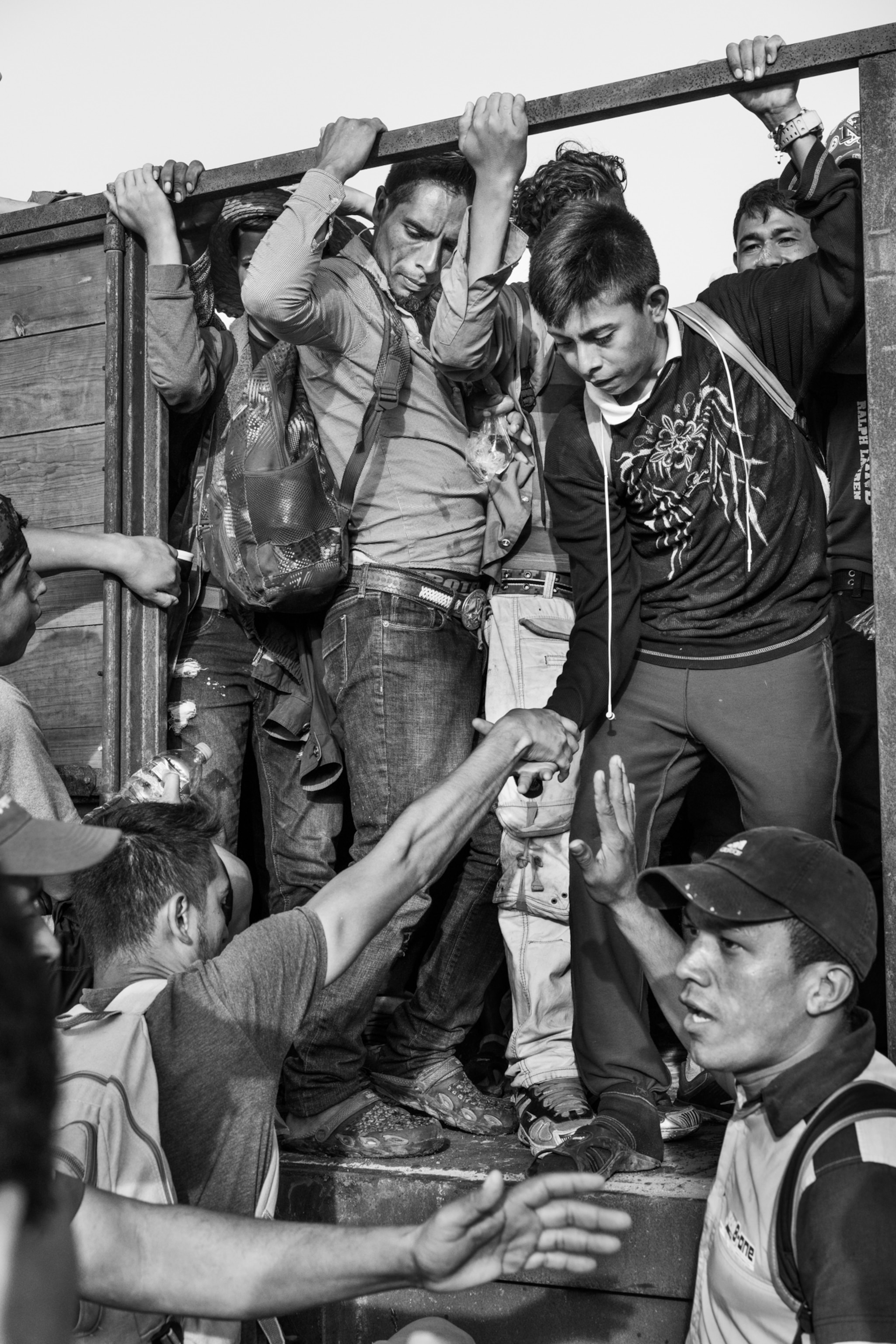 young men getting on a truck and holding onto the frame of the truck