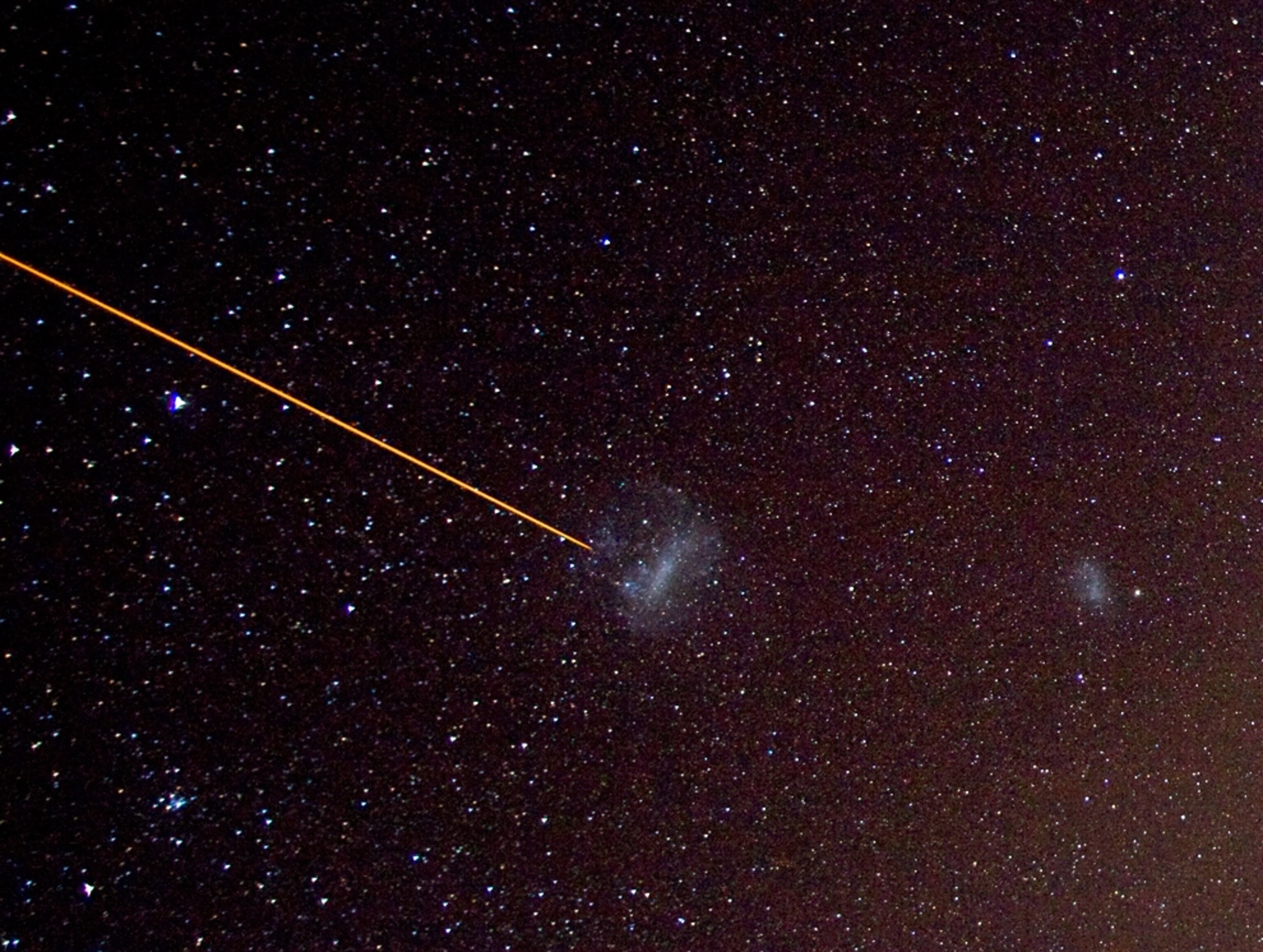 The Large Magellanic Cloud is indicated with a laser, and the Small Magellanic Cloud can be seen at right.