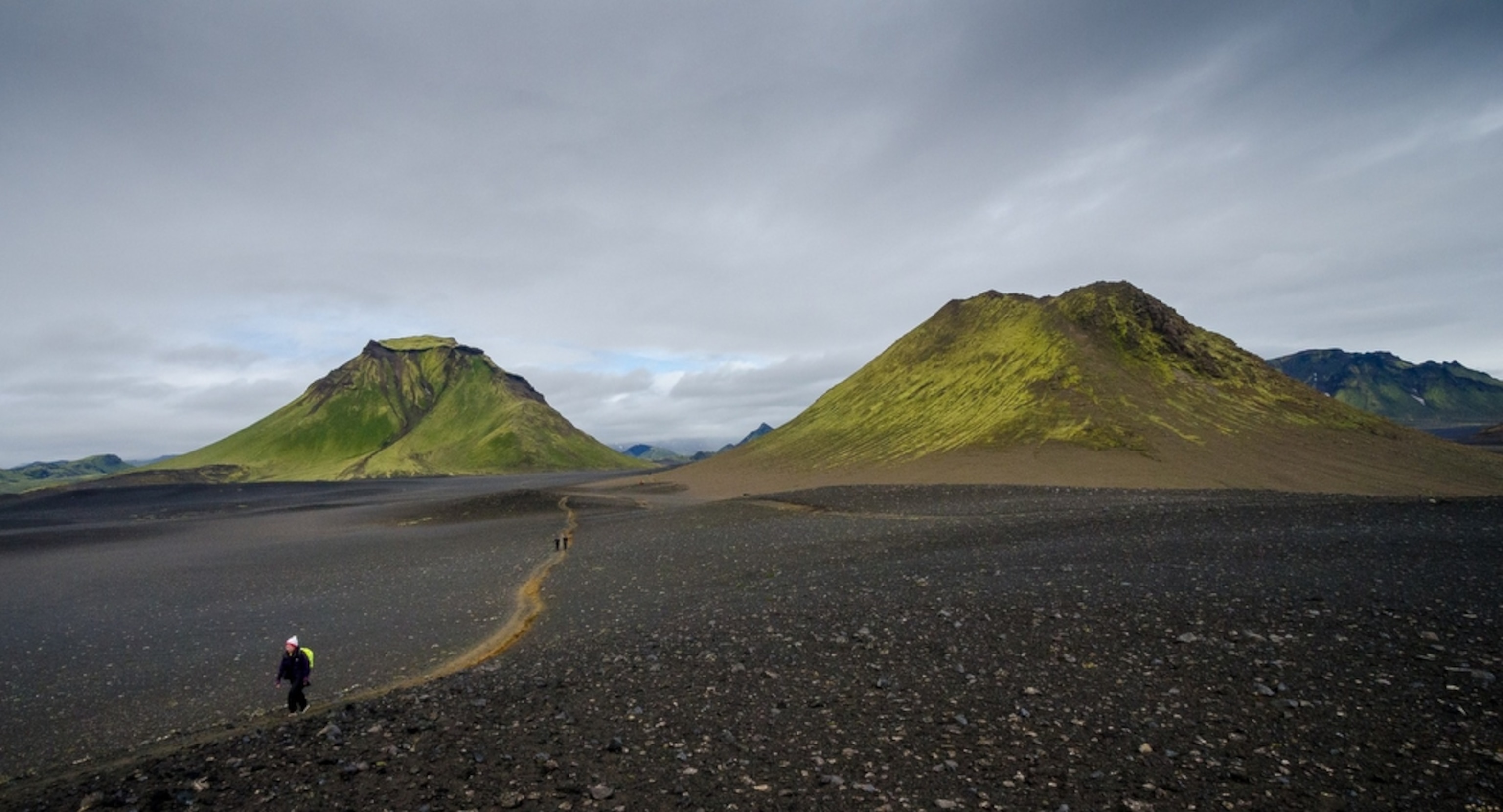 people walking in green hills in Iceland