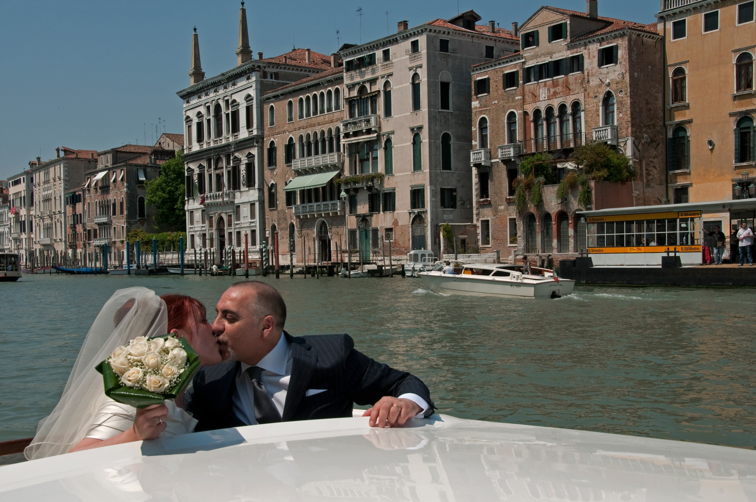 A bride and groom kissing on the Grand Canal.