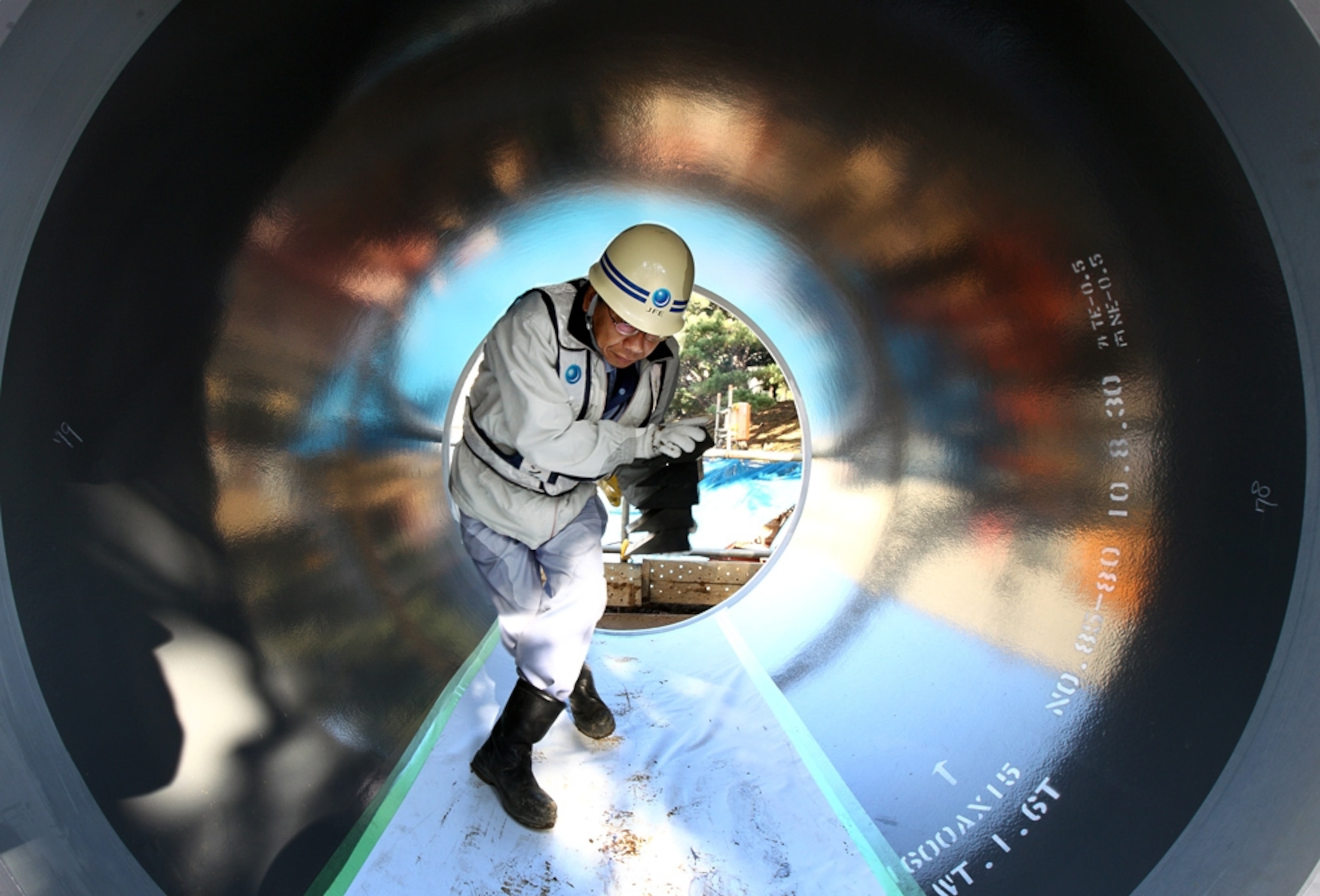 A worker walks through a pipe