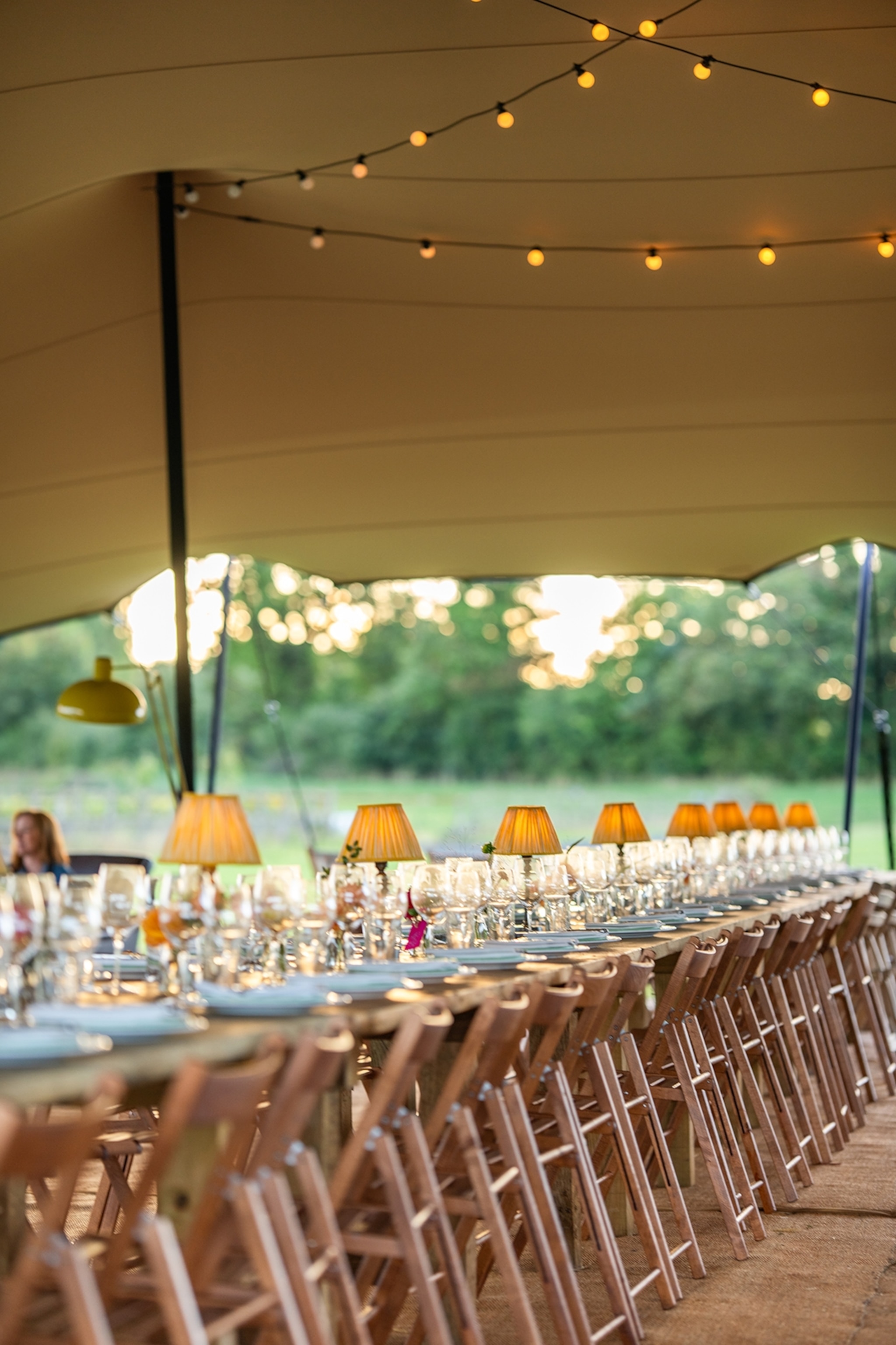 A canopied dinner table on a farm terrace.