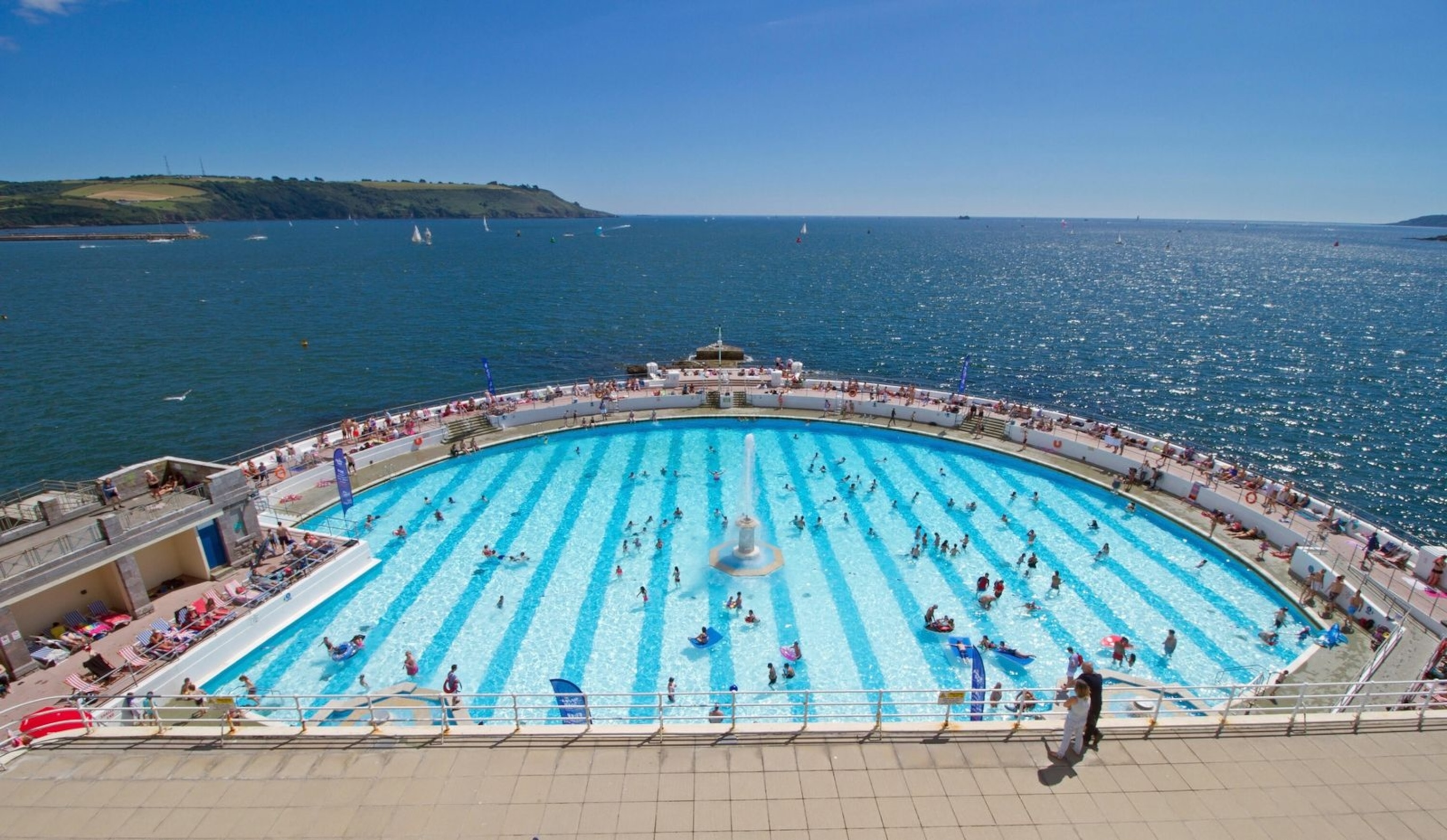 Tinside Lido on Plymouth Hoe, looking over Plymouth Sound. This fabulous Jazz Age complex commands great views and the round pool, stripey bottom and art deco fountain give it a unique shape and style.